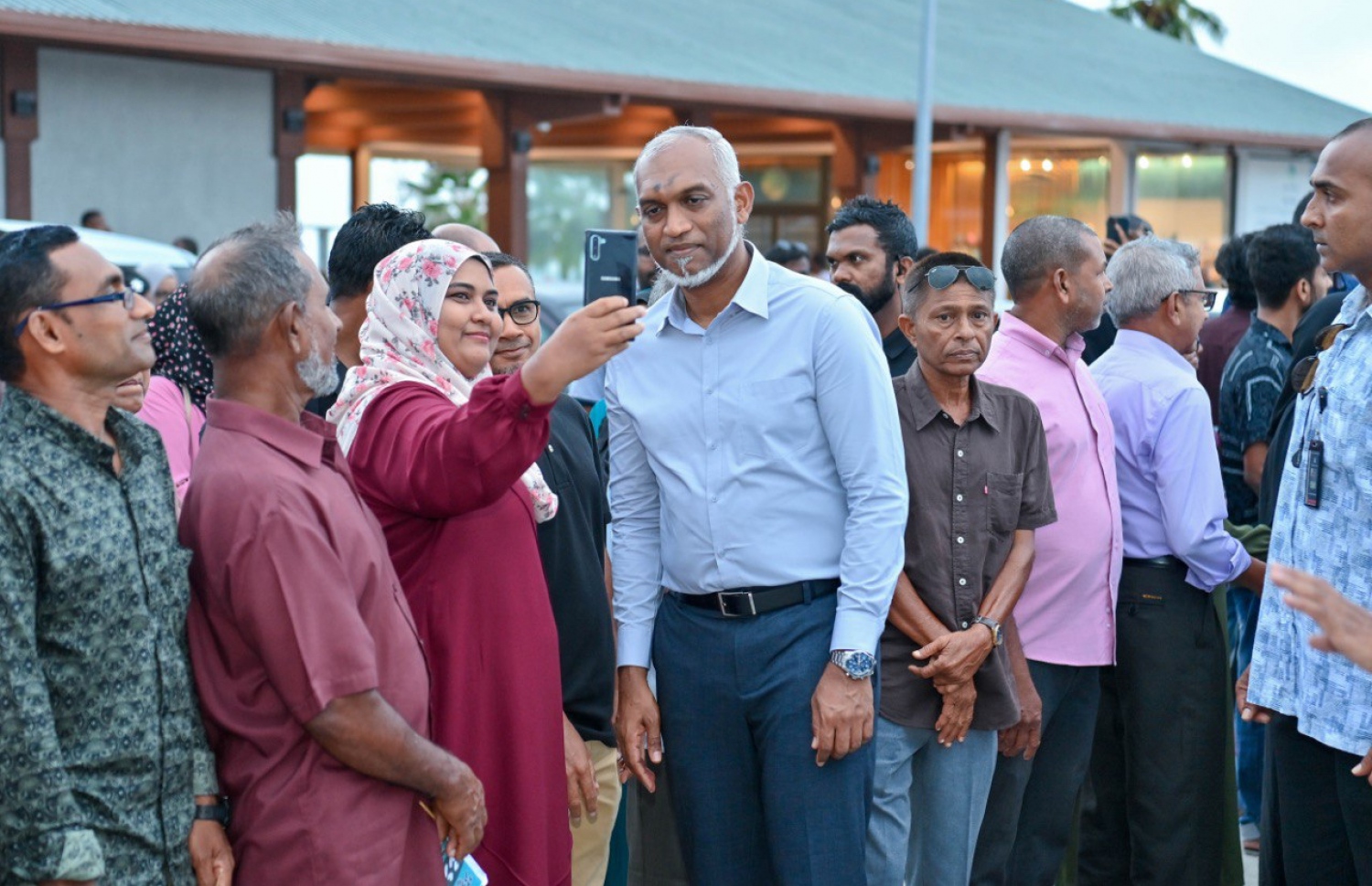 ރައީސް ޑރ. މުއިއްޒު އައްޑުއަށް ވަޑައިގަތުމުން އެމަނިކުފާނަށް މަރުހަބާ ދެންނެވުމަށް ގަން އެއާޕޯޓަށް ގޮސް ތިބި މީހުންގެ ތެރެެއިން ބައެއް މީހުންނާ އެކު ފޮޓޯ ނަންގަވަނީ -- ފޮޓޯ: ޕީއެންސީ