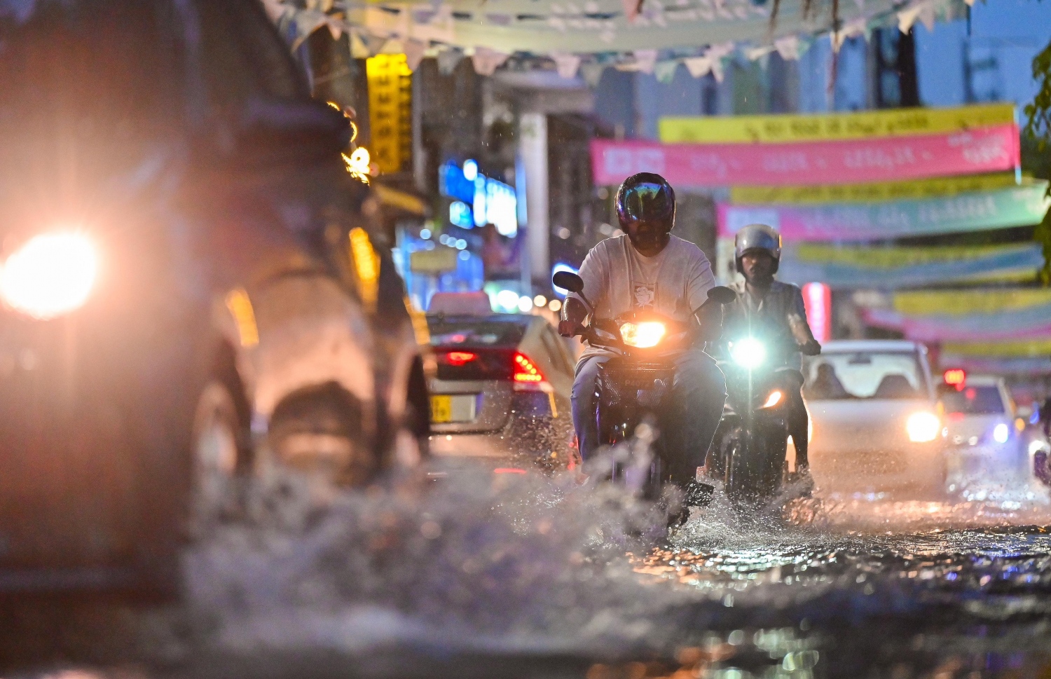 ގަދަ ހޫނަށް ފަހު މާލެއަށް ކުރި ވިއްސާރާގައި މަގުތަކުގައި ފެންބޮޑުވެފައި އޮތް ގަޑީގައި ބަޔަކު ވެހިކަލް ދުއްވާފައި ދަނީ.-- ފޮޓޯ: ފަޔާޒް މޫސާ | މިހާރު