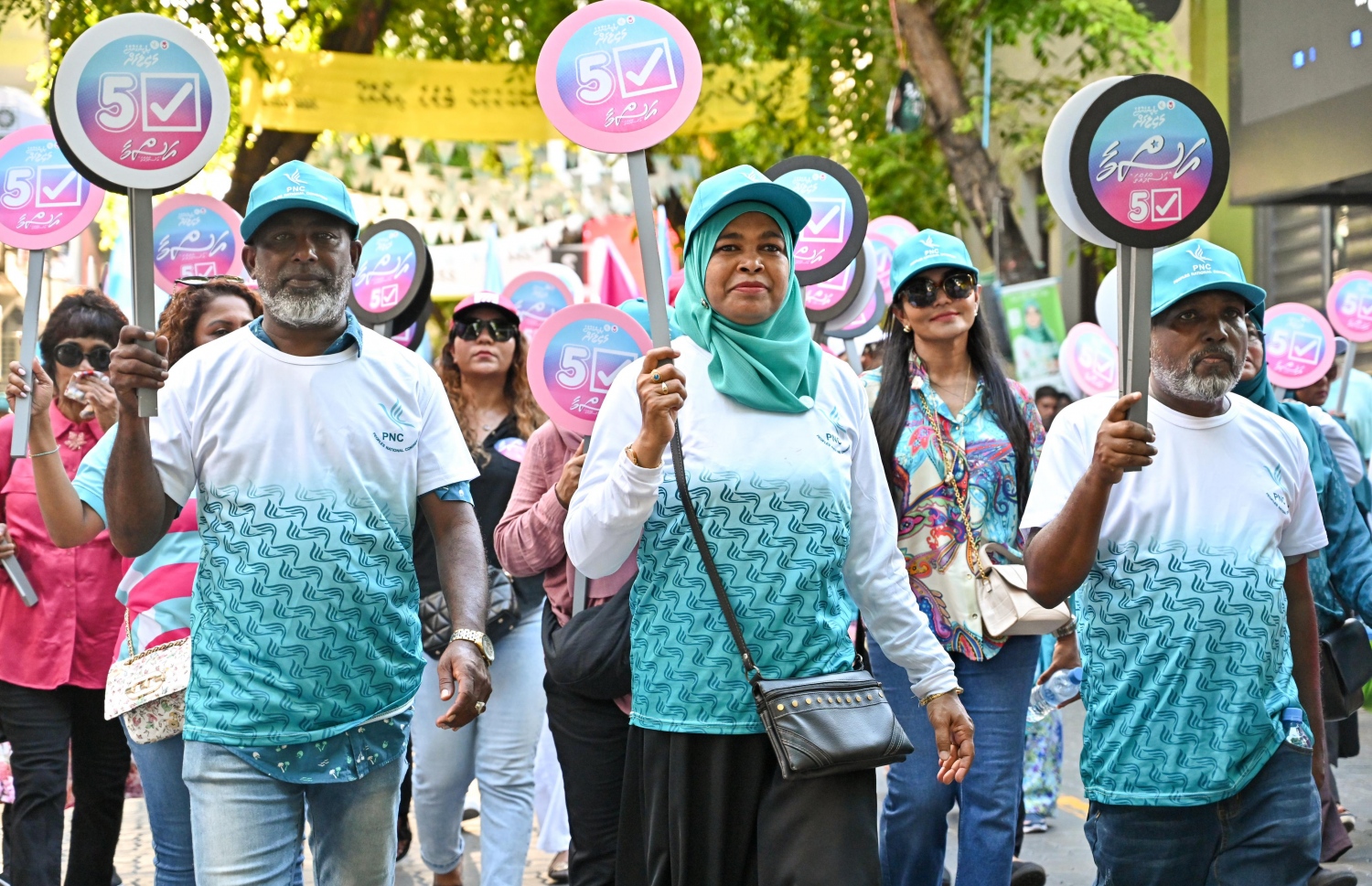 އޭޕްރީލް 20، 2024 - މާލެ: މާދަމާ އޮންނަ ރައްޔިތުންގެ މަޖިލިސްގެ އިންތިހާބުގެ ކެމްޕެއިން ނިންމަށް ޕީއެންސީން ބޭއްވި ހިނގާލުމުގައި ޕާޓީގެ ސަޕޯޓަރުން ކެންޑިޑޭޓުންގެ ނަންތަކާއި ކެންޑިޑޭޓް ނަންބަރު ޖަހާފައިވާ ބޯޑުތަކެއް ހިފައިގެން. -- ފޮޓޯ: ނިޝާން އަލީ | މިހާރު