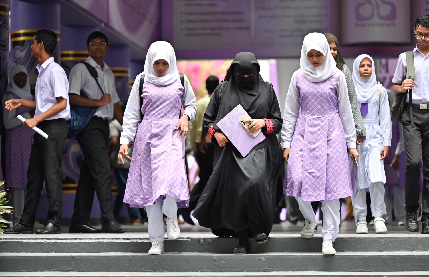 ހިރިޔާ ސްކޫލުގެ ދަރިވަރުންތަކެއް ބެލެނިވެރިޔަކާ އެކު ރިޕޯޓްފޯމް ހިފައިގެންދަނީ.-- ފޮޓޯ: ނިޝާން އަލީ / މިހާރު