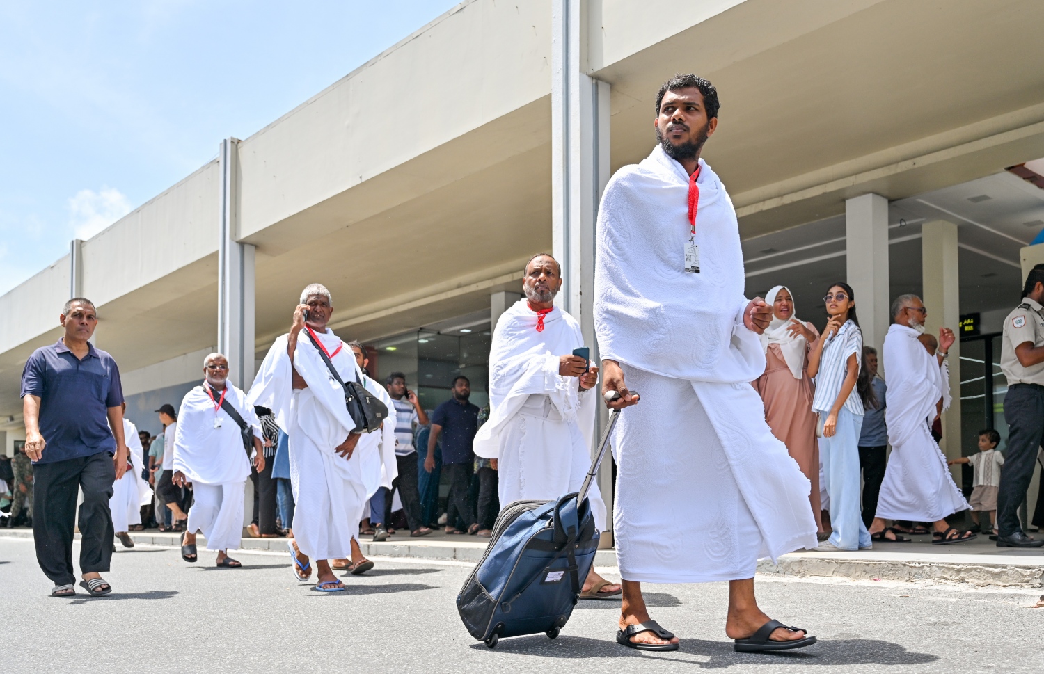 މި އަހަރު ރާއްޖެ އިން ހައްޖަށް ދާ މީހުންގެ ފުރަތަމަ ގްރޫޕްގެ ބައެއް މީހުން މިއަދުގެ މެންދުރު ނަމާދުކުރުމަށް ފަހު ފުރާ ޓާމިނަލަށް ދަނީ -- ފޮޓޯ: ނިޝާން އަލީ | މިހާރު