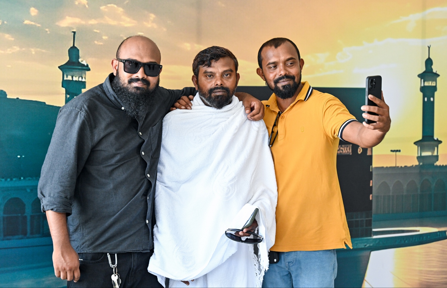 ރާއްޖެ އިން މި އަހަރު ހައްޖަށް ދިއުމަށް މިއަދު ފުރި ފަހު ގުރޫޕުގެ މީހަކު އާއިލާގެ ބަޔަކާ އެކު ވެލާނާ އިންޓަނޭޝަނަލް އެއާޕޯޓުގައި ފޮޓޯއެއް ނަގަނީ.--- ފޮޓޯ: ފަޔާޒު މޫސާ | މިހާރު