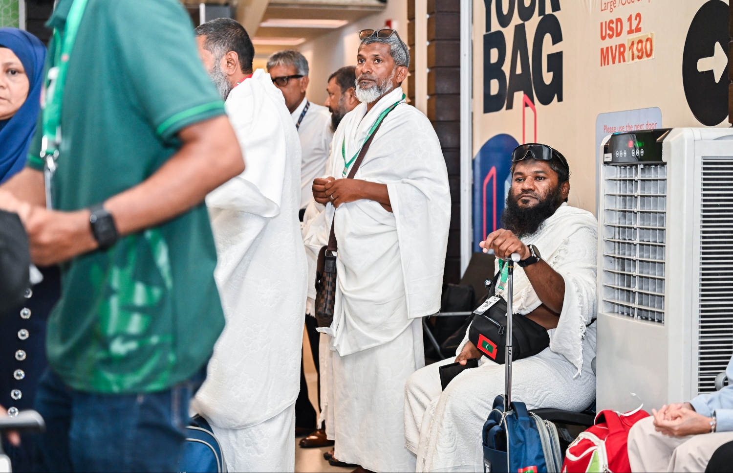 ރާއްޖެ އިން މި އަހަރު ހައްޖަށް ދާ މީހުންގެ ފަހު ގުރޫޕްގެ ބަޔަކު ފުރަން ގޮސް ވެލާނާ އިންޓާނޭޝަނަލް އެއާޕޯޓުގައި މަޑުކޮށްލައިގެން.--- ފޮޓޯ: ފަޔާޒު މޫސާ | މިހާރު