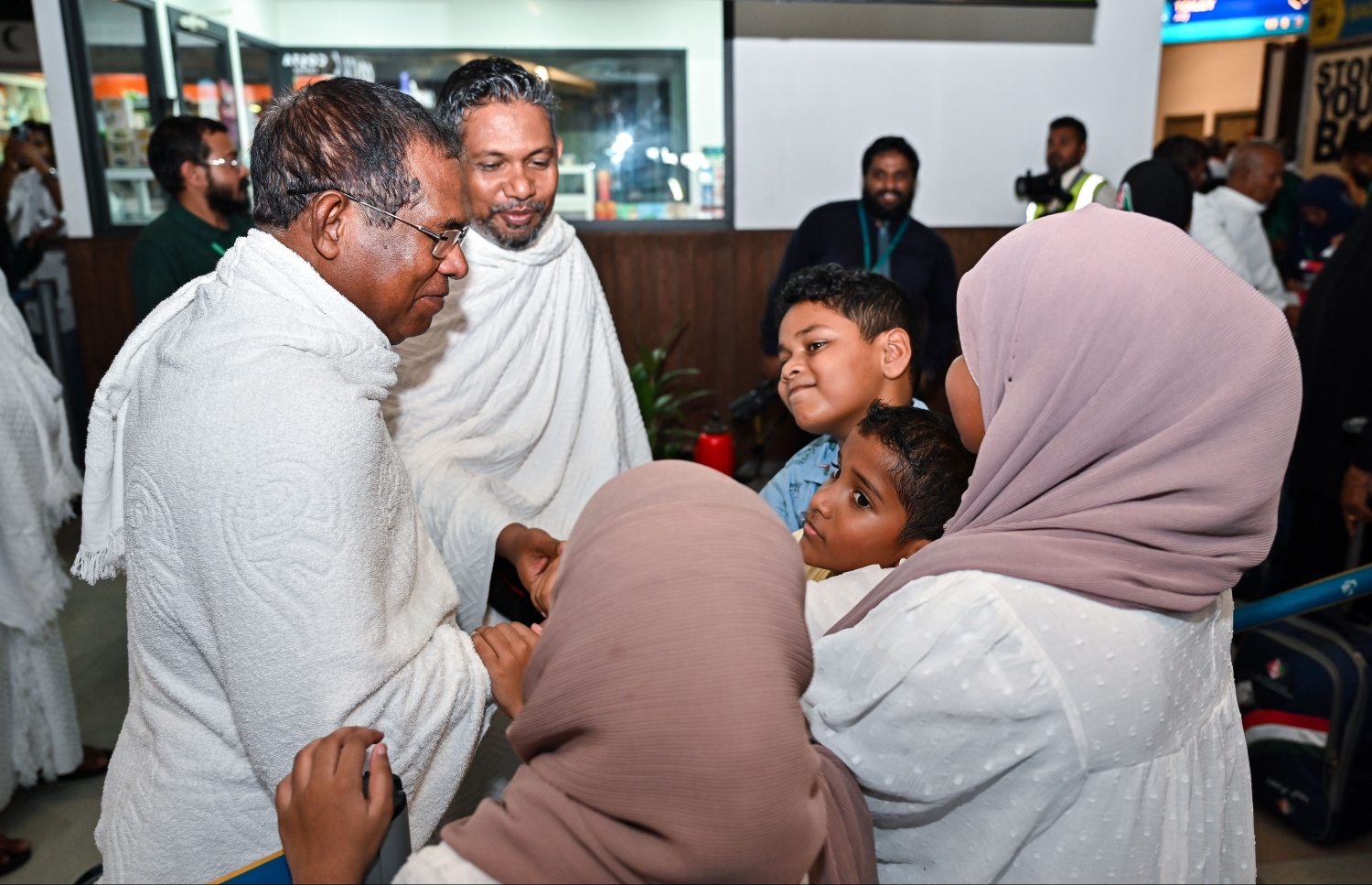 ރާއްޖެ އިން މި އަހަރު ހައްޖަށް ދާ މީހުންގެ ފަހު ގުރޫޕުގެ މީހަކު މިއަދު ފުރުމުގެ ކުރިން އޭނާގެ އާއިލާގެ ކުޑަކުދިންތަކަކާ ސަލާން ކުރަނީ.--- ފޮޓޯ: ފަޔާޒު މޫސާ | މިހާރު