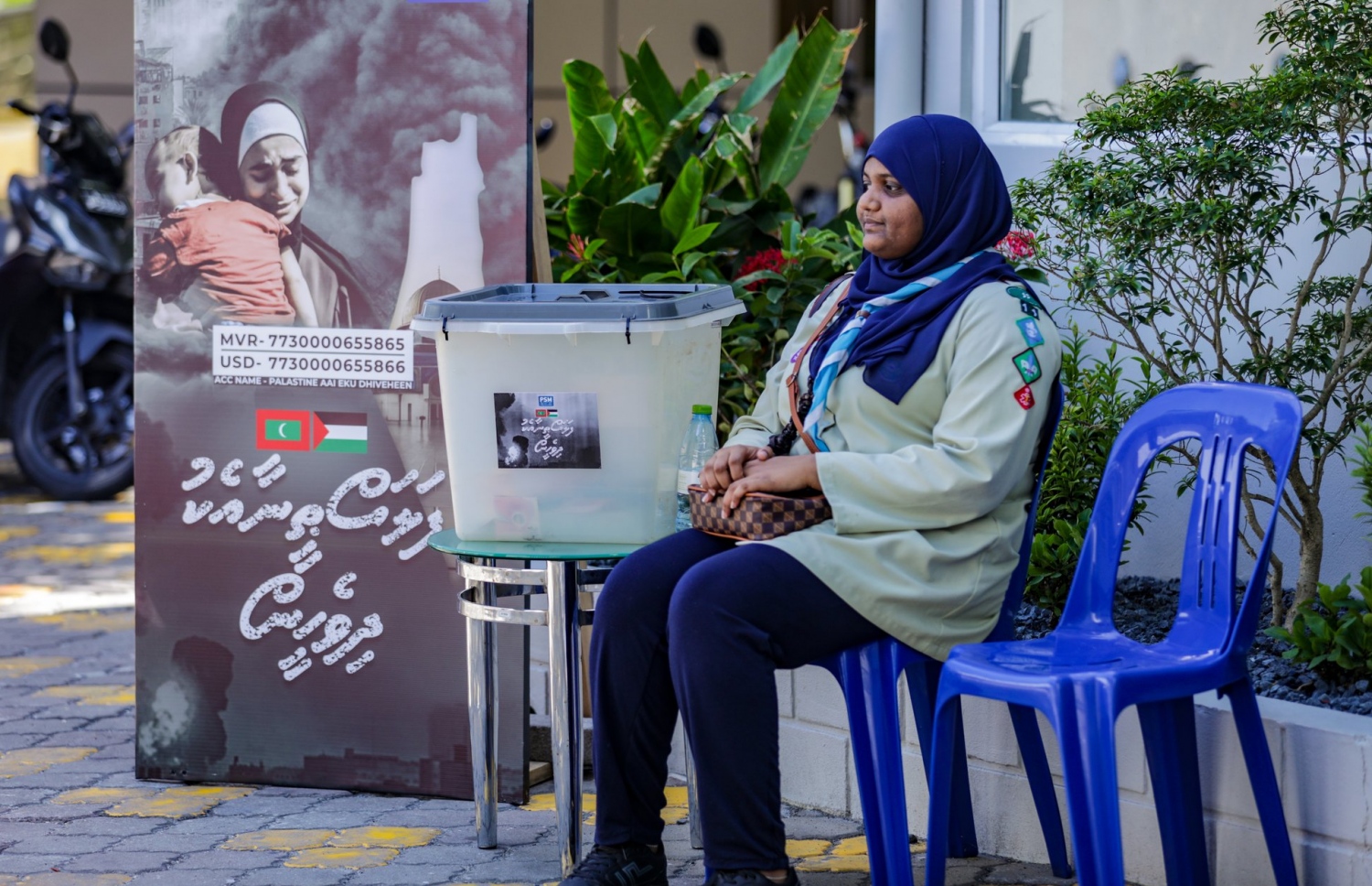 "ފަލަސްތީނާ އެކު ދިވެހީން" ނަމުގައި ރައީސް ޑރ. މުހައްމަދު މުއިއްޒުގެ އިސްނެންގެވުމަކަށް ދައުލަތުގެ މީޑިއާ ޕީއެސްއެމުން އިންތިޒާމު ކޮށްގެން ކުރިއަށް ގެންދިޔަ ޓެލެތޯންގައި މާލޭގައި ބަހައްޓާފައިވާ ފަންޑު ފޮއްޓެއް ކައިރީ ސްކައު ކުއްޖަކު.-- ފޮޓޯ: ޕީއެސްއެމް