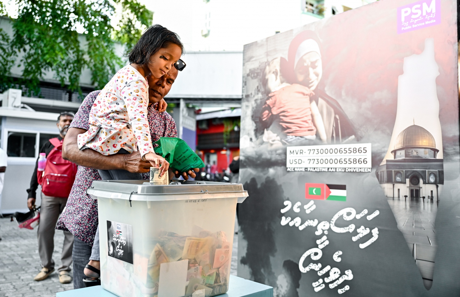 "ފަލަސްތީނާ އެކު ދިވެހީން" ނަމުގައި ދައުލަތުގެ މީޑިއާ ޕީއެސްއެމުން އިންތިޒާމު ކޮށްގެން މިއަދު ކުރިއަށް ގެންދާ ޓެލެތޯންގައި ހުޅުވާފައިވާ ފަންޑު ފޮއްޓަކަށް ކުޑަކުއްޖަކު ރުފިޔާ ލަނީ.-- ފޮޓޯ: ނިޝާން އަލީ | މިހާރު
