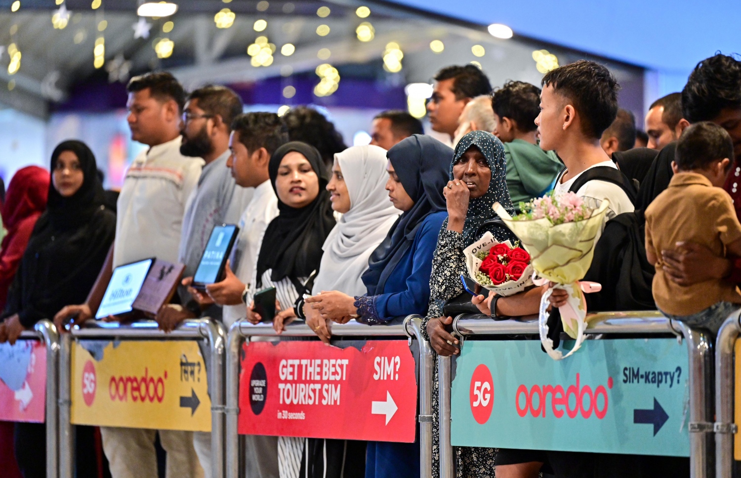 މި އަހަރު ހައްޖަށް ދިޔަ ދެ ދިވެހިން އެނބުރި އަންނާތީ ހައްޖުވެރިންނަށް މަރުހަބާ ކިޔަން އާއިލާތަކުން ވެލާނާ އިންޓަނޭޝަނަލް އެއާޕޯޓުގެ އެރައިވަލް ގޭޓު ކުރިމަތީގައި މަޑުކޮށްލައިގެން.-- ފޮޓޯ: ފަޔާޒް މޫސާ | މިހާރު