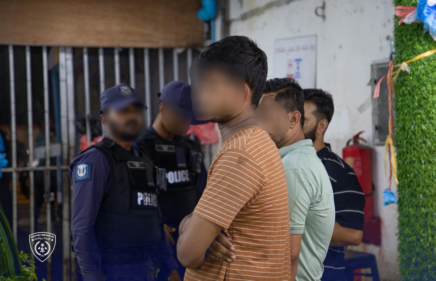 އިމިގްރޭޝަން އާއި ފުލުހުން ގުޅިގެން ހިންގި ރެއިޑްގައި ބަންދުކުރި ބައެއް ބިދޭސީން.-- ފޮޓޯ: އިމިގްރޭޝަން