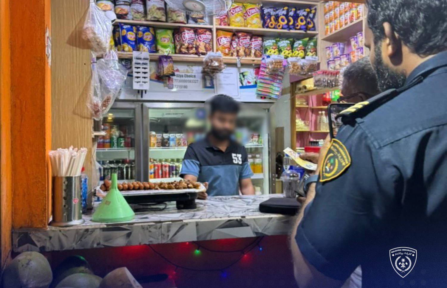 ހުޅުމާލެ 1ގައި ގަވާއިދާ ހިލާފަށް ވިޔަފާރި ހިންގާ ބިދޭސީން އަތުލައިގަންނަން ހިންގި ރެއިޑް އޮޕަރޭޝަންގައި އިމިގްރޭޝަން އޮފިސަރަކު، ބިދޭސީއަކު ހިންގާ ހަޓެއް ކައިރީގައި މަޑުކޮށްލައިގެން.---ފޮޓޯ: އިމިގްރޭޝަން