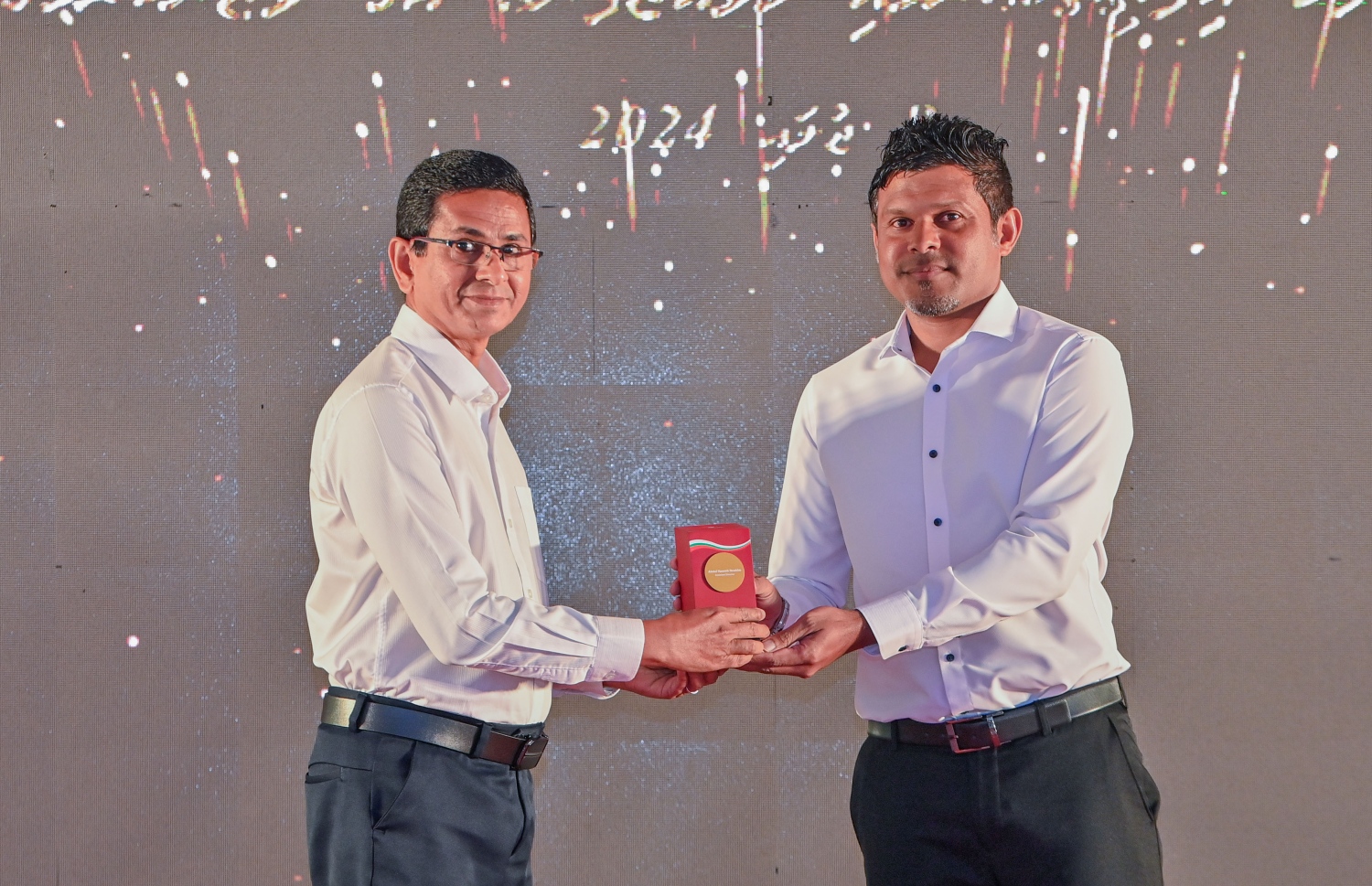 އޭސީސީގެ މުވައްޒަފުންގެ އަގުވަޒަންކުރުމަށް ބޭއްވި ރަސްމިއްޔާތުގައި ނައިބު ރައީސް ހުސެއިން، އެ ކޮމިޝަނަށް ގިނަ ދުވަހު ހިދުމަތްކުރެއްވި މުވައްޒަފަކަށް ހަދާނީ ފިލާ އަރުއްވަނީ.-- ފޮޓޯ: ރައީސް އޮފީސް