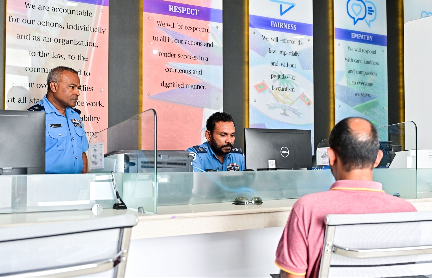 ހުޅުމާލެ ޕޮލިސް ސްޓޭޝަނަށް މީހަކު ޝަކުވާއެއް ހުށަހަޅާއިރު، ފުލުހުންތަކެއް ރިސެޕްޝަންގައި މަޑުކޮށްލައިގެން.-- ފޮޓޯ: ފަޔާޒު މޫސާ/ މިހާރު