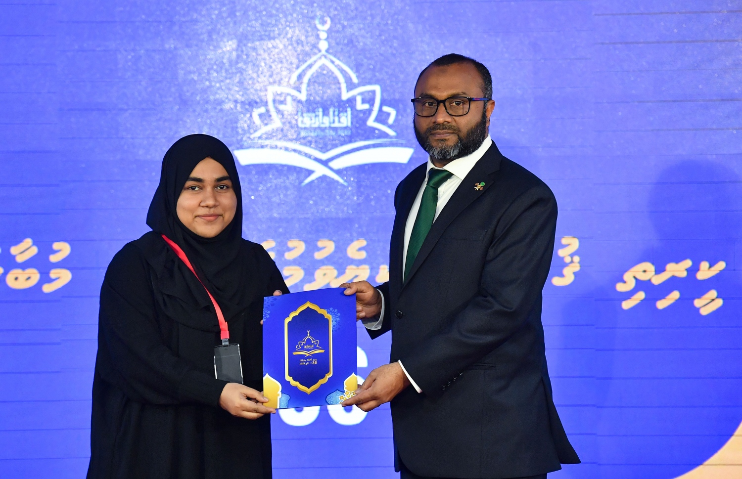 ގުރުއާން ކިޔެވުމުގެ 36 ވަނަ ގައުމީ މުބާރާތުގެ ނަތީޖާ ފާޅުކުރުމަށް ބޭއްވި ޖަލްސާގައި އިސްލާމިކް މިނިސްޓަރު ޑރ. މުހައްމަދު ޝަހީމް އަލީ ސައީދު، މީހަކާ އިނާމް ހަވާލުކުރައްވަނީ.-- ފޮޓޯ: ރައީސް އޮފީސް