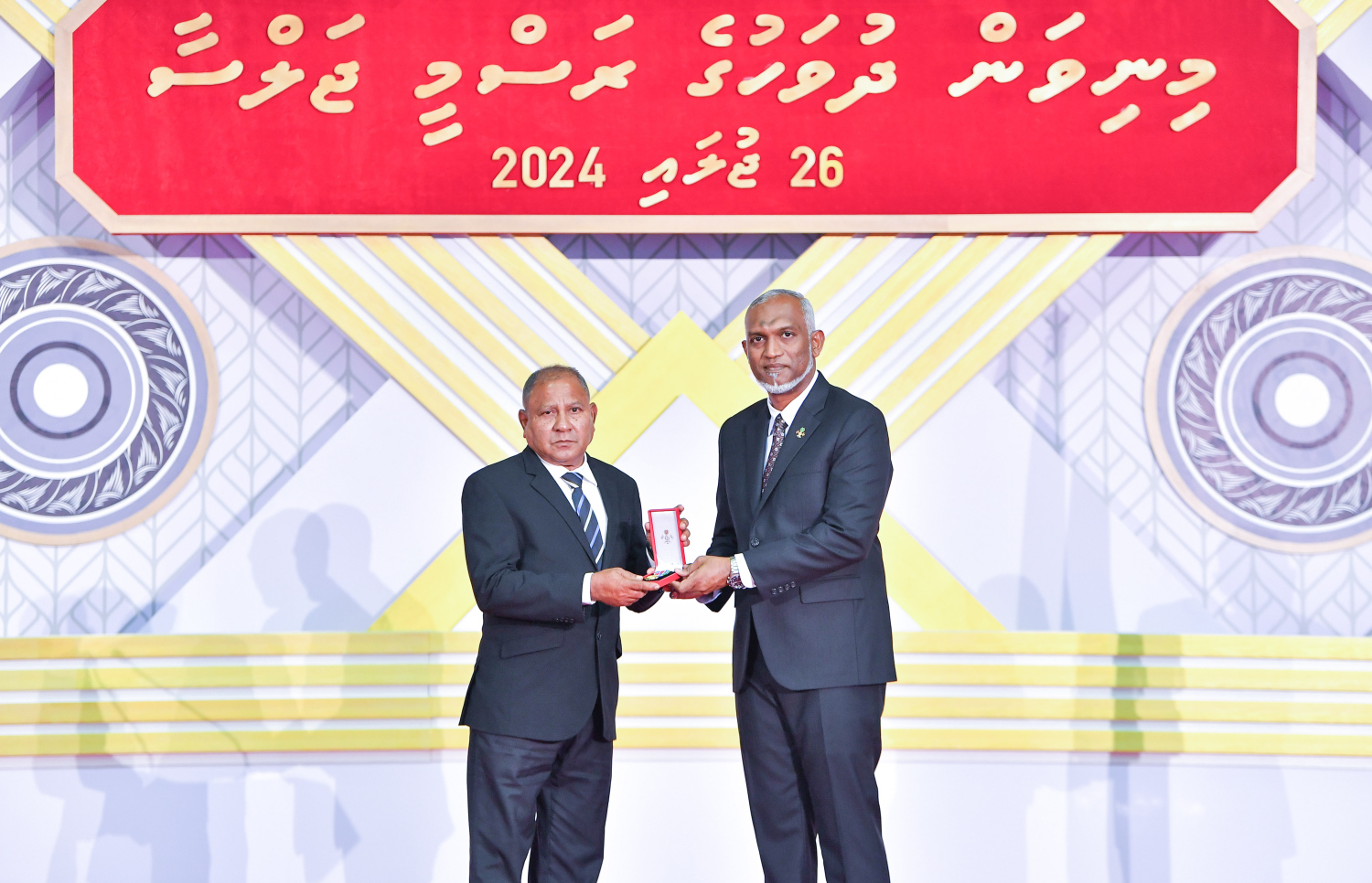 ދިވެހި ދައުލަތަށް ދިގު މުއްދަތަކަށް ހިދުމަތް ކުރެއްވި ބޭފުޅެއްގެ ހިދުމަތުގެ އަގު ވަޒަން ކުރައްވައި، ރައީސް މުއިއްޒު ޝަރަފުގެ ބެޖާއި އައްޑަނަ ދެއްވަނީ.--- ފޮޓޯ: ރައީސް އޮފީސް