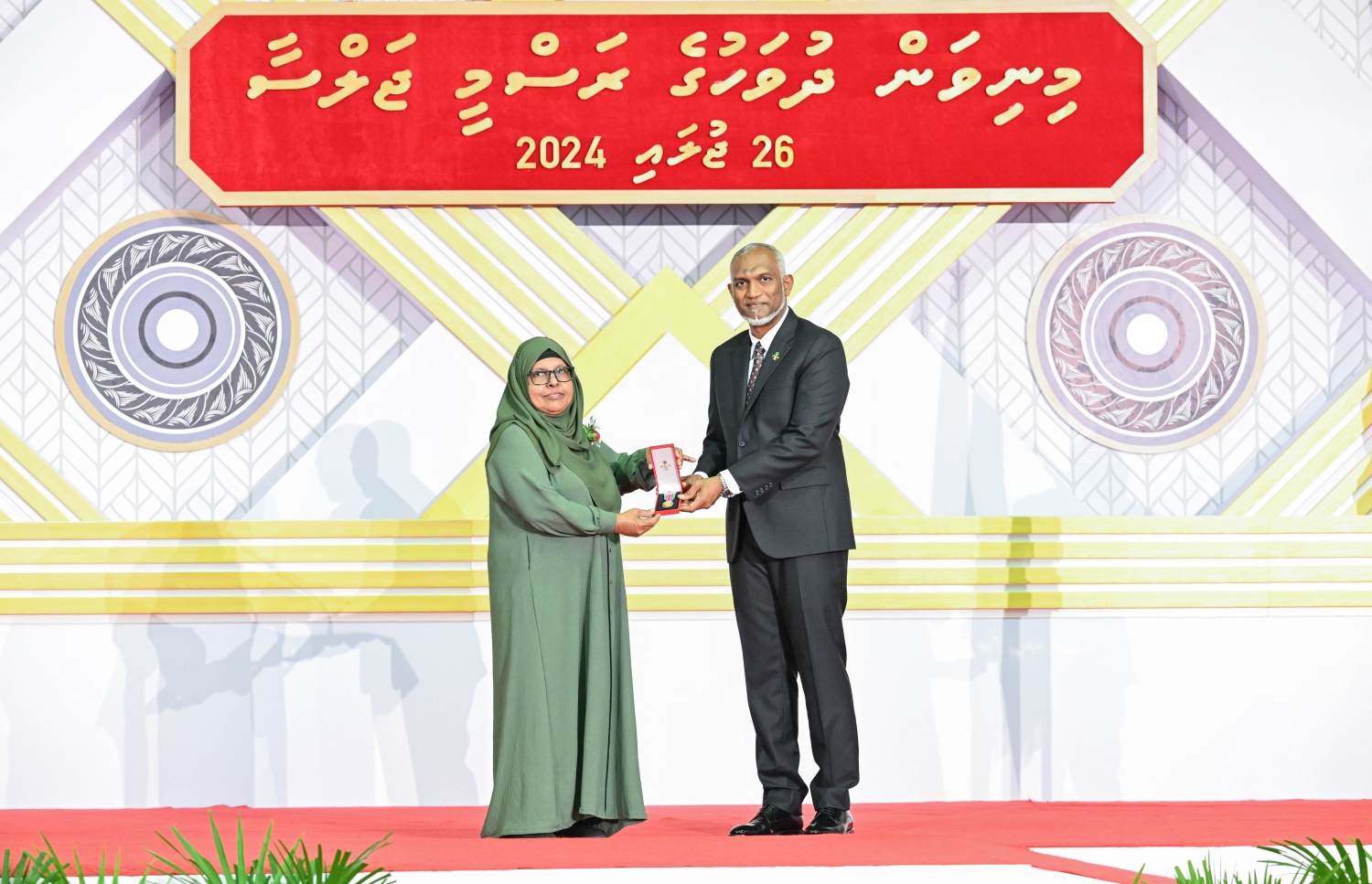 ދިވެހި ދައުލަތަށް ދިގު މުއްދަތަކަށް ހިދުމަތް ކުރެއްވި ބޭފުޅެއްގެ ހިދުމަތުގެ އަގު ވަޒަން ކުރައްވައި، ރައީސް މުއިއްޒު ޝަރަފުގެ ބެޖާއި އައްޑަނަ ދެއްވަނީ.--- ފޮޓޯ: ރައީސް އޮފީސް