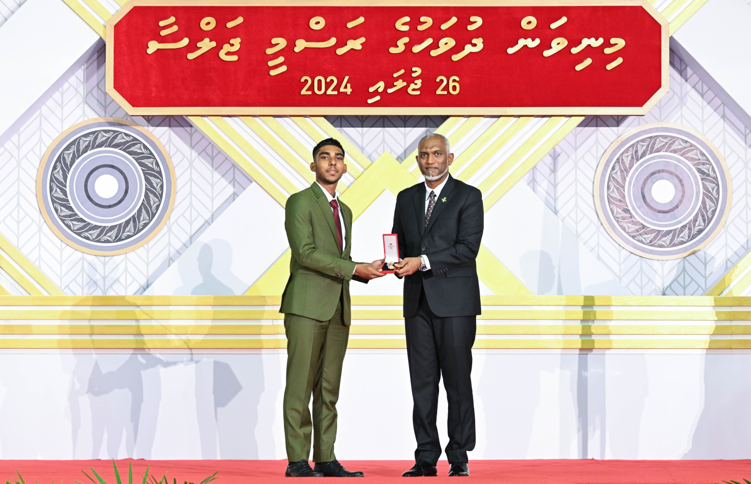 މި އަހަރުގެ މިނިވަން ދުވަހުގެ ރަސްމީ ޖަލްސާގައި ރައީސް މުއިއްޒު އިނާމު ދެއްވަނީ: ދައުލަތަށް ގިނަ ދުވަސްތަކެއް ވަންދެން ހިދުމަތް ކުރެއްވި ގިނަ ބޭފުޅުންތަކަކަށް ރޭ އިނާމު ދެއްވި.---ފޮޓޯ: ރައީސް އޮފީސް