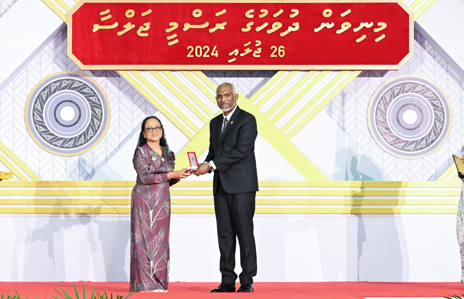 ދިވެހި ދައުލަތަށް ދިގު މުއްދަތަކަށް ހިދުމަތް ކުރެއްވި ބޭފުޅެއްގެ ހިދުމަތުގެ އަގު ވަޒަން ކުރައްވައި، ރައީސް މުއިއްޒު ޝަރަފުގެ ބެޖާއި އައްޑަނަ ދެއްވަނީ.--- ފޮޓޯ: ރައީސް އޮފީސް