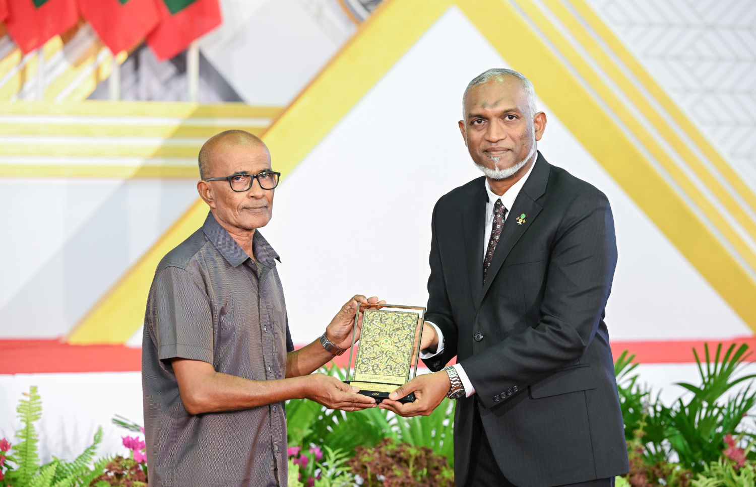 ދިވެހި ދައުލަތަށް ދިގު މުއްދަތަކަށް ހިދުމަތް ކުރެއްވި ބޭފުޅެއްގެ ހިދުމަތުގެ އަގު ވަޒަން ކުރައްވައި، ރައީސް މުއިއްޒު ޝަރަފުގެ ބެޖާއި އައްޑަނަ ދެއްވަނީ.--- ފޮޓޯ: ރައީސް އޮފީސް