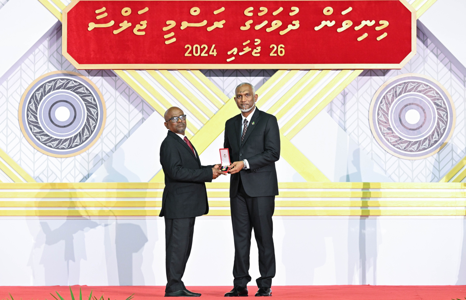 ދިވެހި ދައުލަތަށް ދިގު މުއްދަތަކަށް ހިދުމަތް ކުރެއްވި ބޭފުޅެއްގެ ހިދުމަތުގެ އަގު ވަޒަން ކުރައްވައި، ރައީސް މުއިއްޒު ޝަރަފުގެ ބެޖާއި އައްޑަނަ ދެއްވަނީ.--- ފޮޓޯ: ރައީސް އޮފީސް