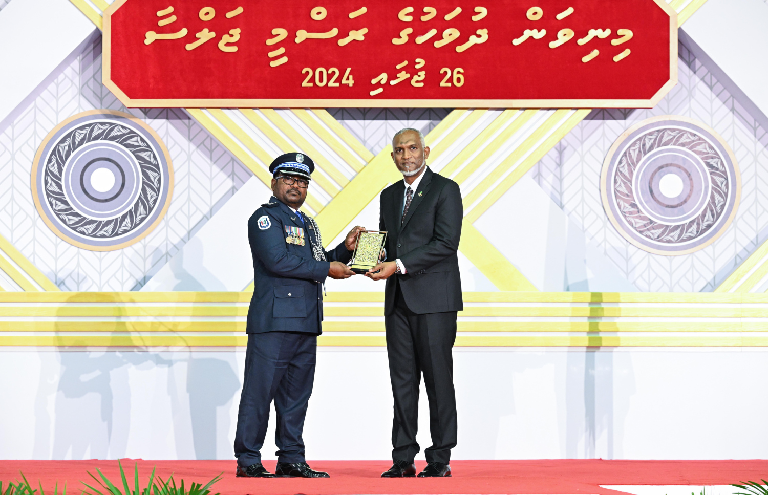 ދިވެހި ދައުލަތަށް ދިގު މުއްދަތަކަށް ހިދުމަތް ކުރެއްވި ބޭފުޅެއްގެ ހިދުމަތުގެ އަގު ވަޒަން ކުރައްވައި، ރައީސް މުއިއްޒު ޝަރަފުގެ ބެޖާއި އައްޑަނަ ދެއްވަނީ.--- ފޮޓޯ: ރައީސް އޮފީސް