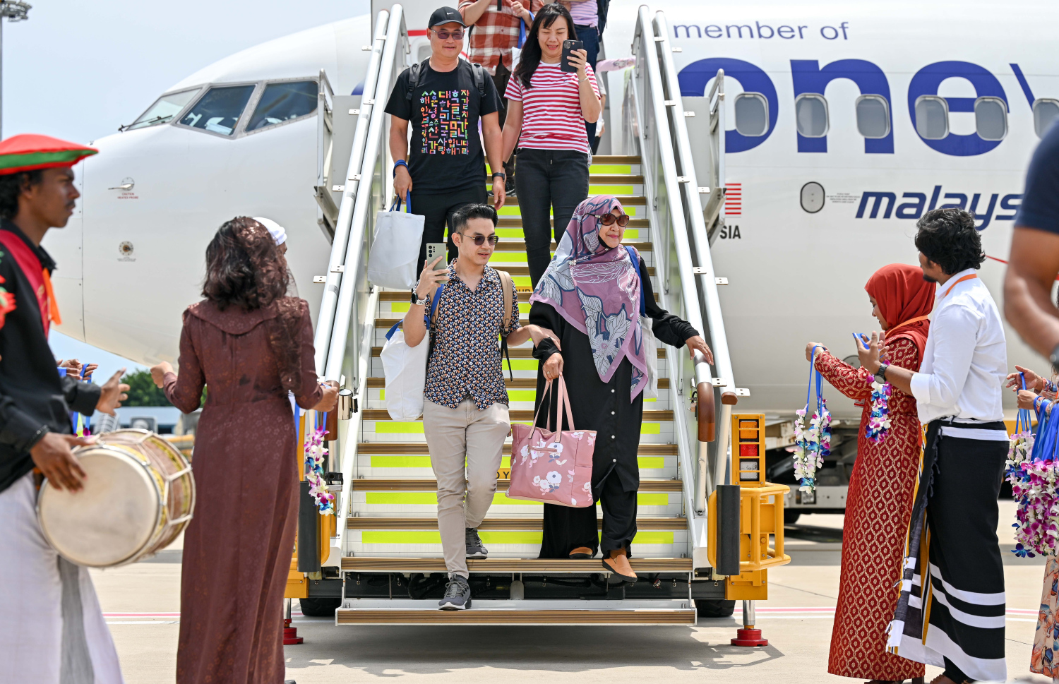 މެލޭޝިއާ އެއާލައިނުން މިއަދު ރާއްޖެ އައި ފަސިންޖަރުންނަށް މަރުހަބާ ކިޔަނީ. -- ފޮޓޯ: ނިޝާން އަލީ | މިހާރު