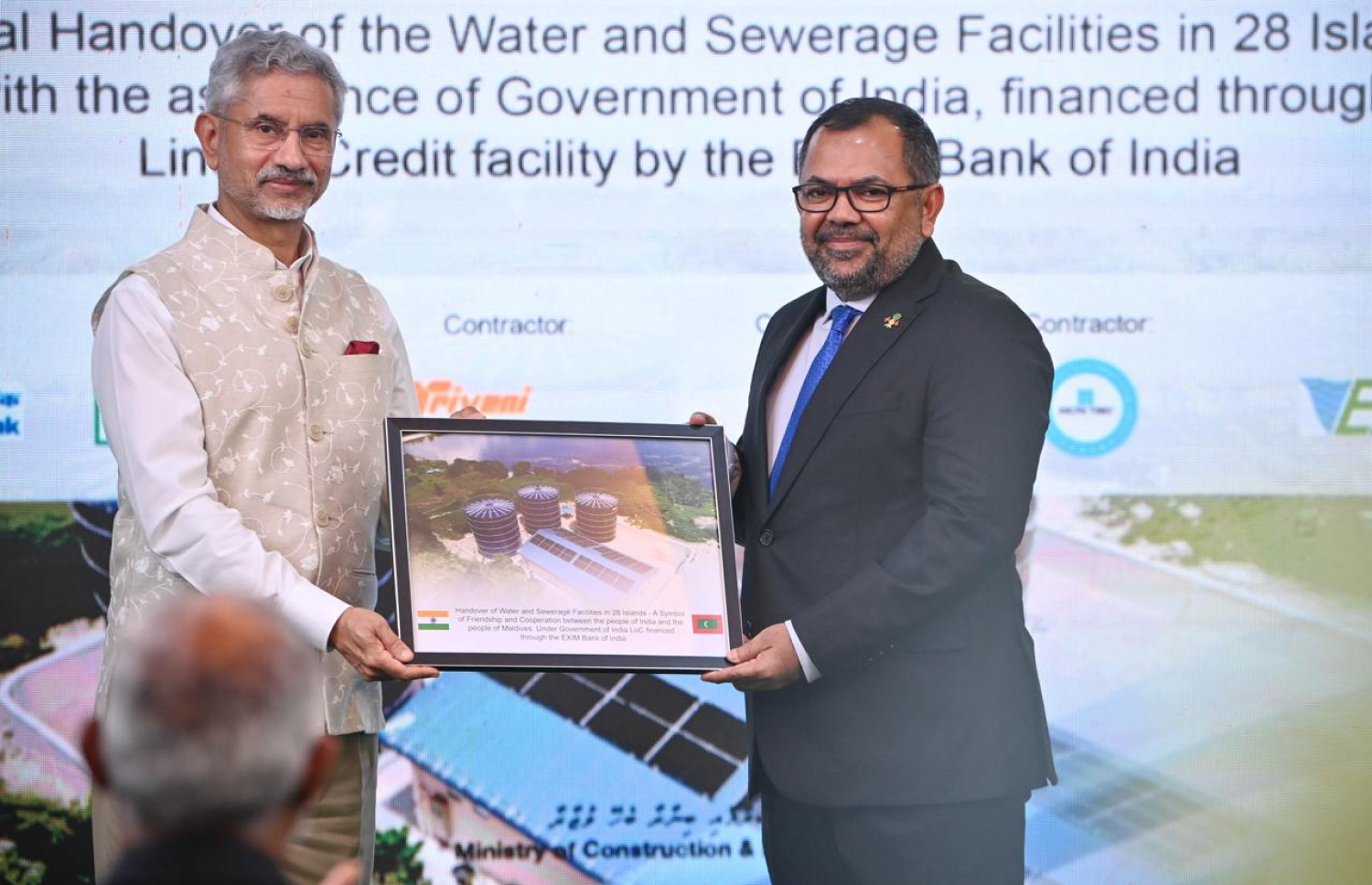 އިންޑިއާގެ އެގްޒިމް ބޭންކުގެ ލައިން އޮފް ކްރެޑިޓްގެ ދަށުން ރާއްޖޭގެ 28 ރަށެއްގައި ފެނާއި ނަރުދަމާ ގާއިމްކުރުމަށް ހިންގި މަޝްރޫއުތައް ނިމުނު ކަމުގެ ލިޔުން، އިންޑިއާގެ އެކްސްޓާނަލް އެފެއާޒް މިނިސްޓަރު ޖައިޝަންކަރު، ފޮރިން މިނިސްޓަރު ޒަމީރާ ހަވާލުކޮށްދެއްވަނީ.-- ފޮޓޯ: ރައީސް އޮފީސް