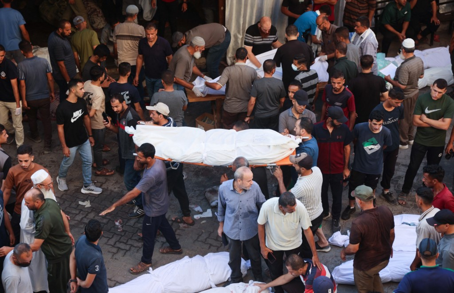 ޣައްޒާގެ ސްކޫލެއްގައި ފަތިސް ނަމާދަށް މީހުން ތިއްބާ ދިން ހަމަލާގައި ޝަހީދުވި މީހުންގެ ހަށިތައް ގެންދަނީ. -- ފޮޓޯ: އޭއެފްޕީ