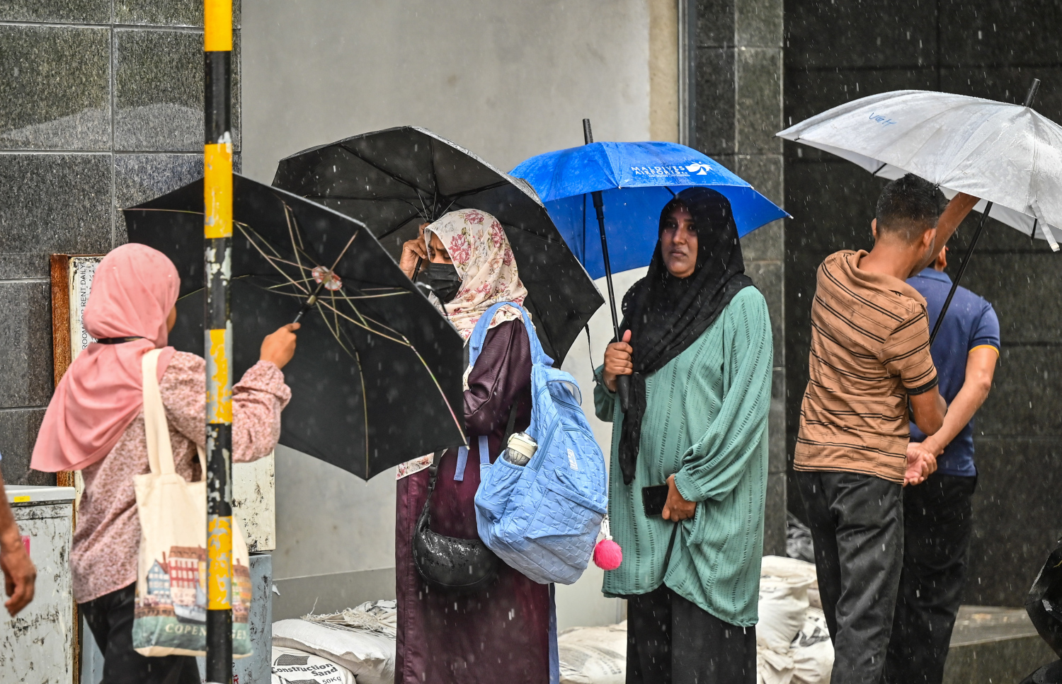 ވިއްސާރާގައި ކުޑަ ނަގައިގެން މާލޭގެ މަގެއް މަތީގައި ބަޔަކު މަޑުކޮށްލައިގެން.-- ފޮޓޯ: މިހާރު