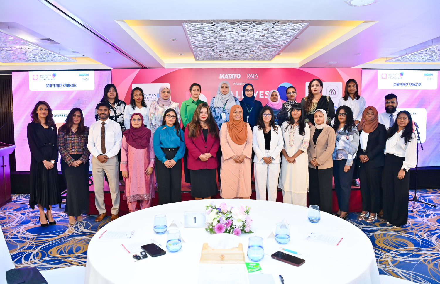 މޯލްޑިވްސް ޓްރެވަލް ކޮންފަރެންސް - ވިމެންސް އެޑިޝަން 2024" ހުޅުވުމުގެ ރަސްމިއްޔާތުގައި ޓޫރިޒަމް އިންޑަސްޓްރީގައި މަސައްކަތްކުރާ އަންހެނުންގެ ޕެނަލްގައި ހިމެނޭ ބައިވެރިން، ފަސްޓް ލޭޑީއާ އެކު ގްރޫޕް ފޮޓޯއަކަށް ހުއްޓިގެން. -- ފޮޓޯ | ރައީސް އޮފީސް