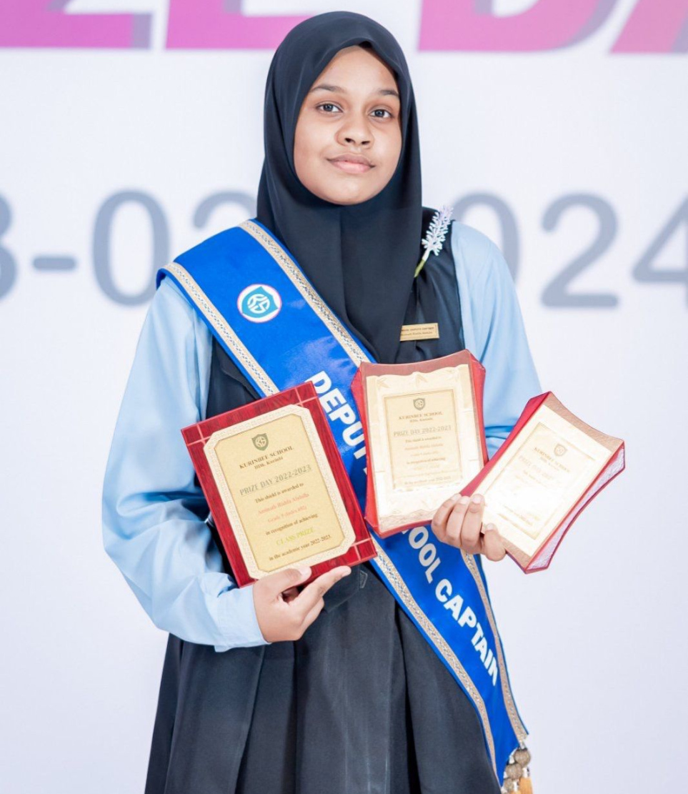 ރިޝްފާ އަށް ލިބުނު ޓްރޮފީތަކެއް ހިފައިގެން.