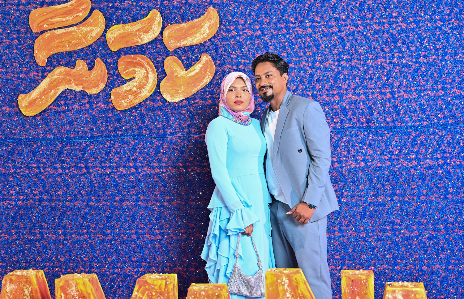 ހުސައިން މުނައްވަރު ޑައިރެކްޓް ކޮށްގެން ގެނެސްދޭ "ކަމަނާ" ގެ ޕްރިމިއާގައި އެ ފިލްމުގެ ޑައިރެކްޓަރު ހުސައިން މުނައްވަރު އޭނާގެ އަންހެނުންނާ އެކު ފޮޓޯއަކަށް ހުއްޓިލައިގެން. .-- ފޮޓޯ: ނިޝާން އަލީ | މިހާރު