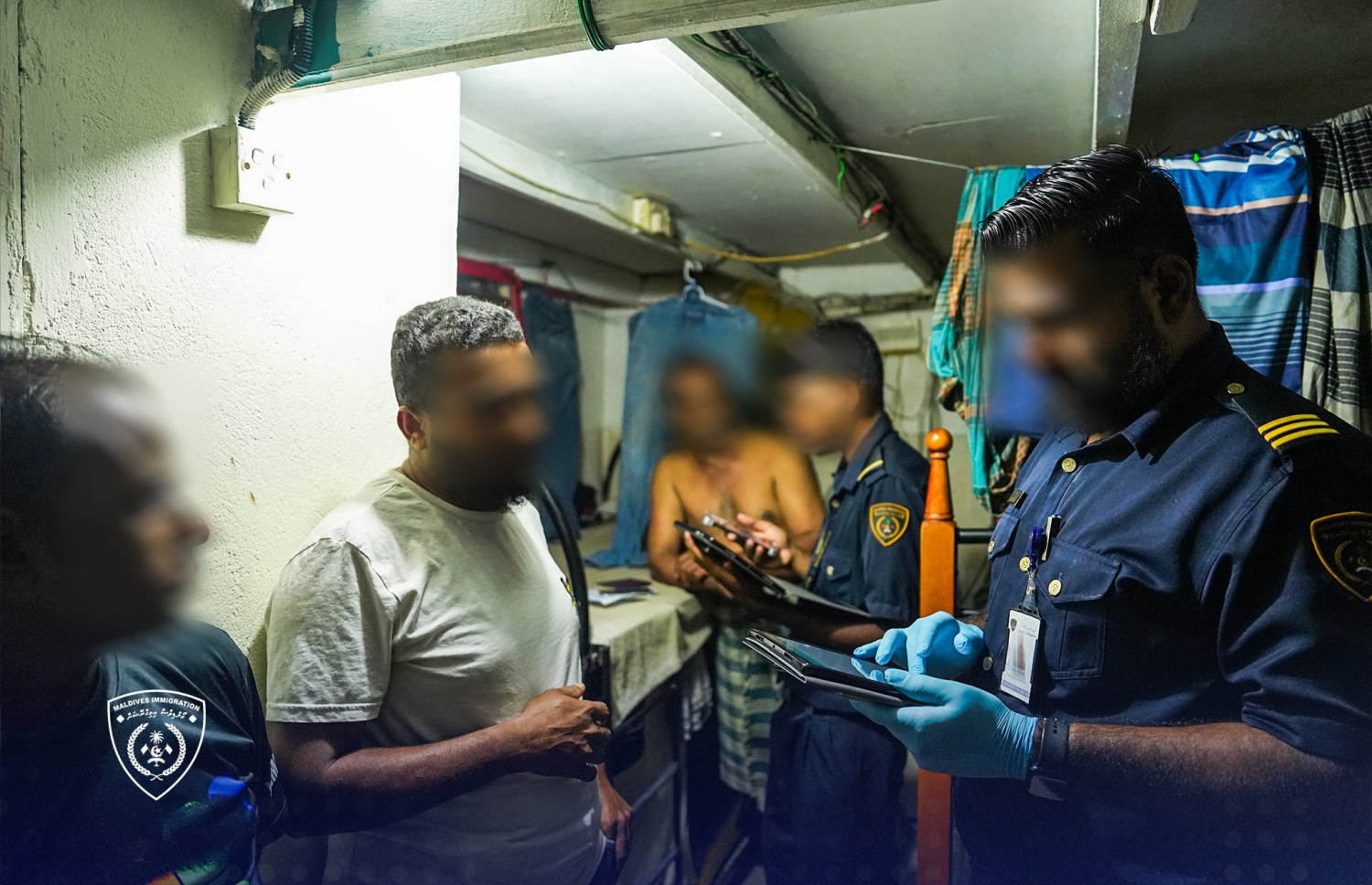 އިމިގްރޭޝަންގެ އޮފިސަރުން ބިދޭސީން ދިރިއުޅޭ ގެއެއް ބަލައި ފާސްކުރަނީ.-- ފޮޓޯ: އިމިގްރޭޝަން