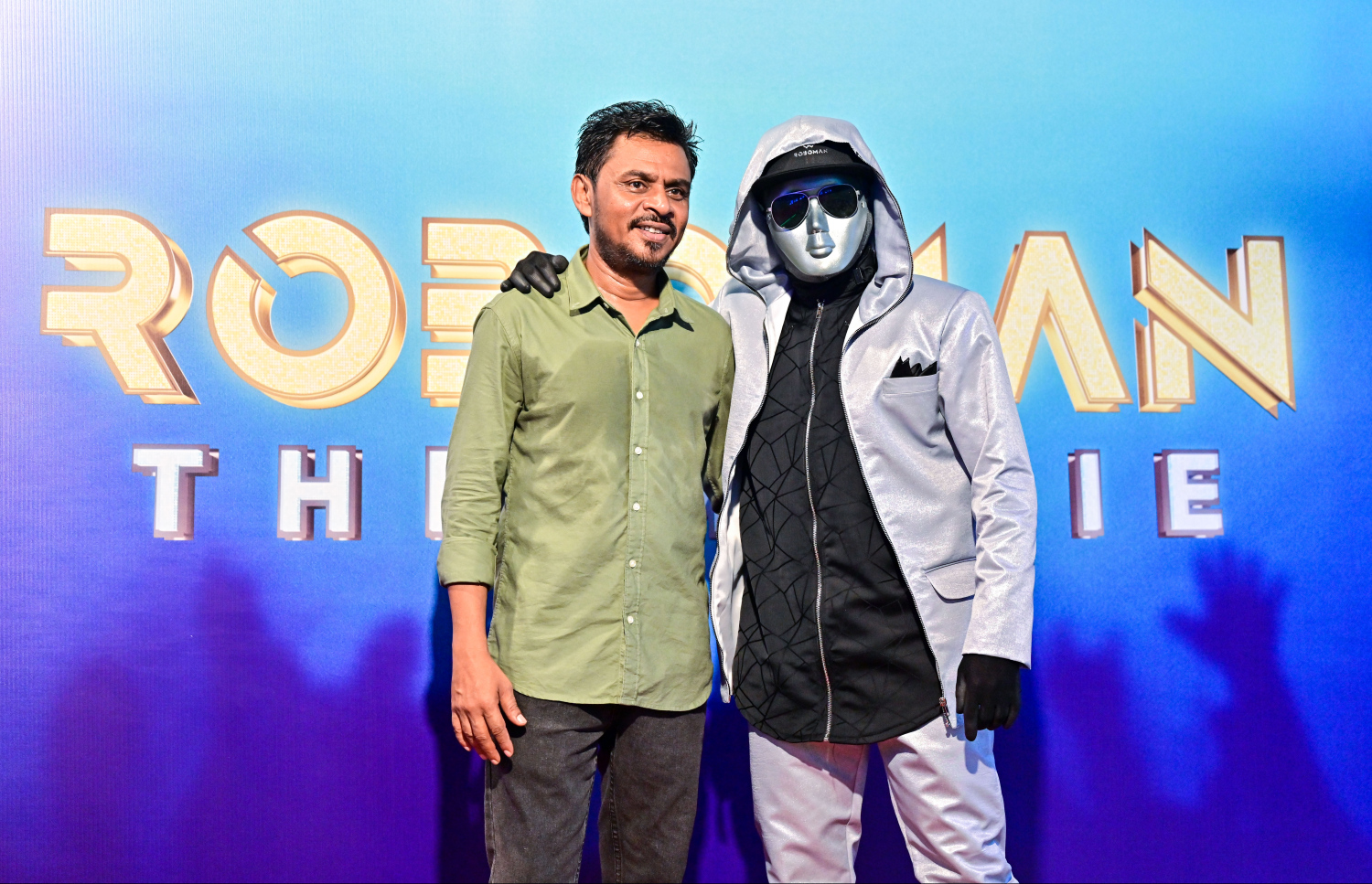 ކުޑަކުދިންގެ ފިލްމް "ރޮބޯމޭން: ދަ މޫވީ"ގެ ރެޑްކާޕެޓް: ރޮބޯމޭންއާ އެކު ފިލްމުގެ ޑައިރެކްޓަރު އިބްރާހިމް ވިސާމް (ކަނޑި).-- ފޮޓޯ: ފަޔާޒް މޫސާ | މިހާރު