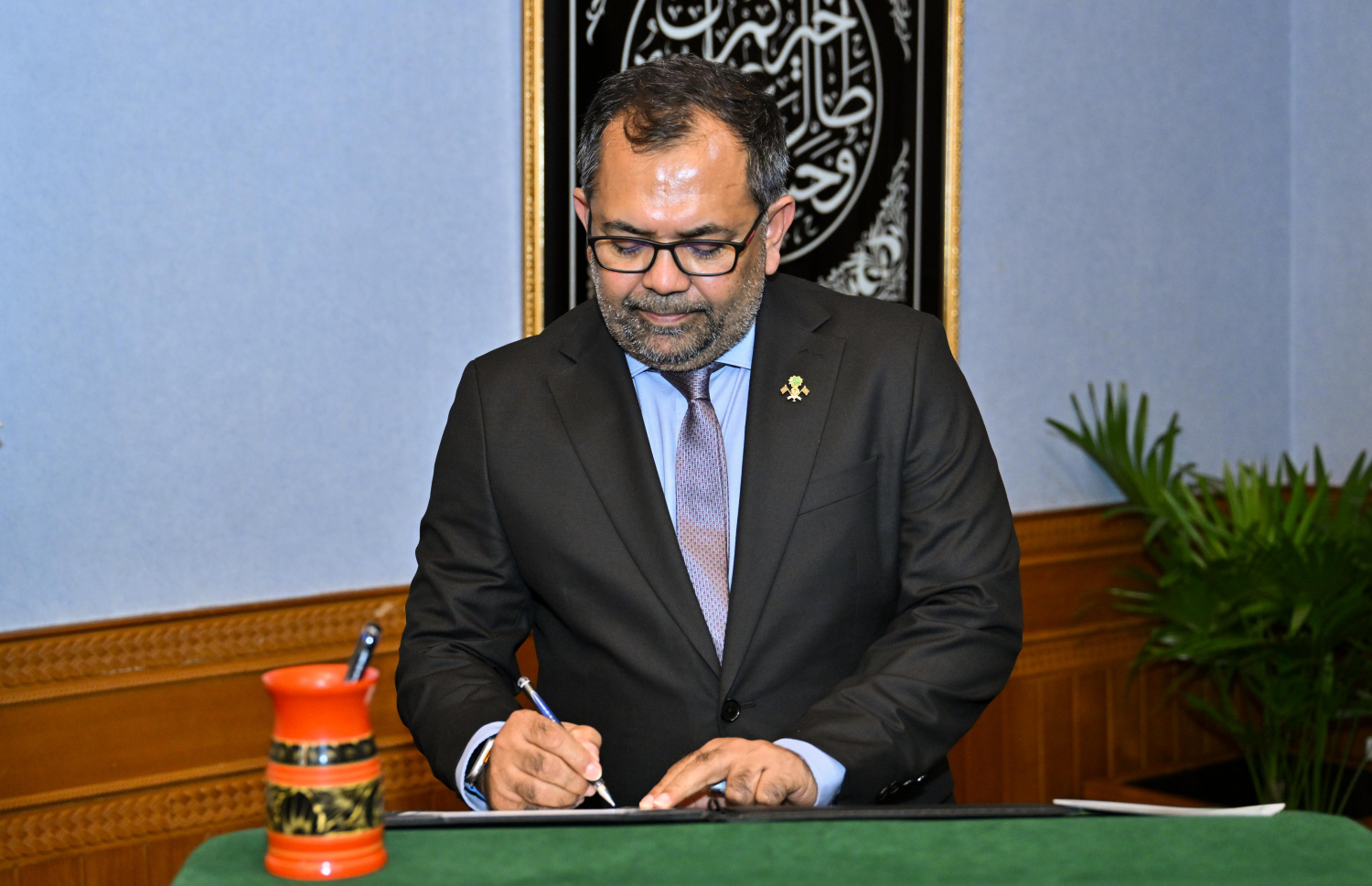 ފިނޭންސް މިނިސްޓަރަކަށް ބަދަލުކުރެއްވި ކުރެއްވި ޒަމީރު ހުވާގެ ލިޔުމުގައި ސޮއިކުރައްވަނީ -- ފޮޓޯ: ރައީސް އޮފީސް