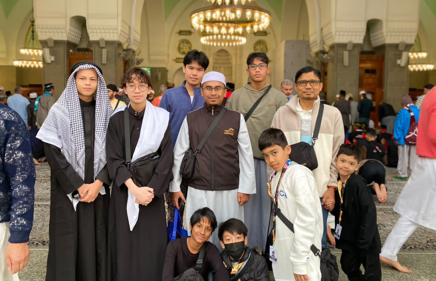 އިންޓަނޭޝަނަލް އިސްލާމިކް ސްކޫލު މެލޭޝިއާގައި ކިޔަވަމުން އަންނަ ޔަޝްއަލް، އޭނާގެ ސްކޫލު ޓީޗަރުންނާއި އޭނާއާ އެކު ކިޔަވާ ކުދިނާ އެކު ފޮޓޯއަކަށް ހުއްޓިގެން.