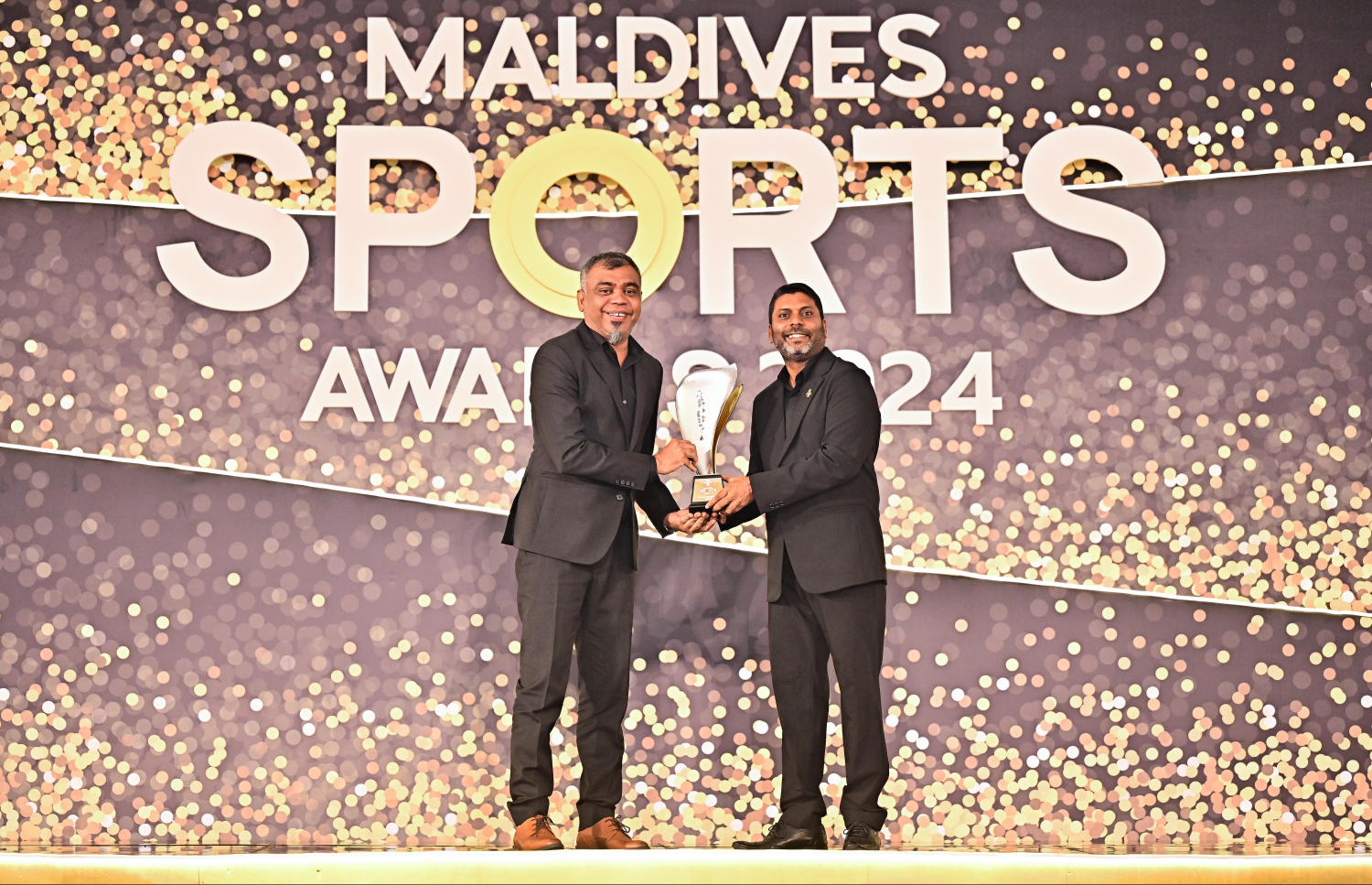 ކުޅިވަރަށް އެކި ގޮތްގޮތުން ހިދުމަތް ކޮށްދީފައިވާތީ އޮލިމްޕިކް ކޮމިޓީގެ ކުރީގެ ޖެނެރަލް ސެކްރެޓަރީ އަހްމަދު މަރުޒޫގް (މަރޭ) އަށް ސްޕޯޓްސް މިނިސްޓަރު އަބްދުﷲ ރާފިއު އެވޯޑް ދެއްވަނީ.--- ފޮޓޯ: ފަޔާޒު މޫސާ | މިހާރު