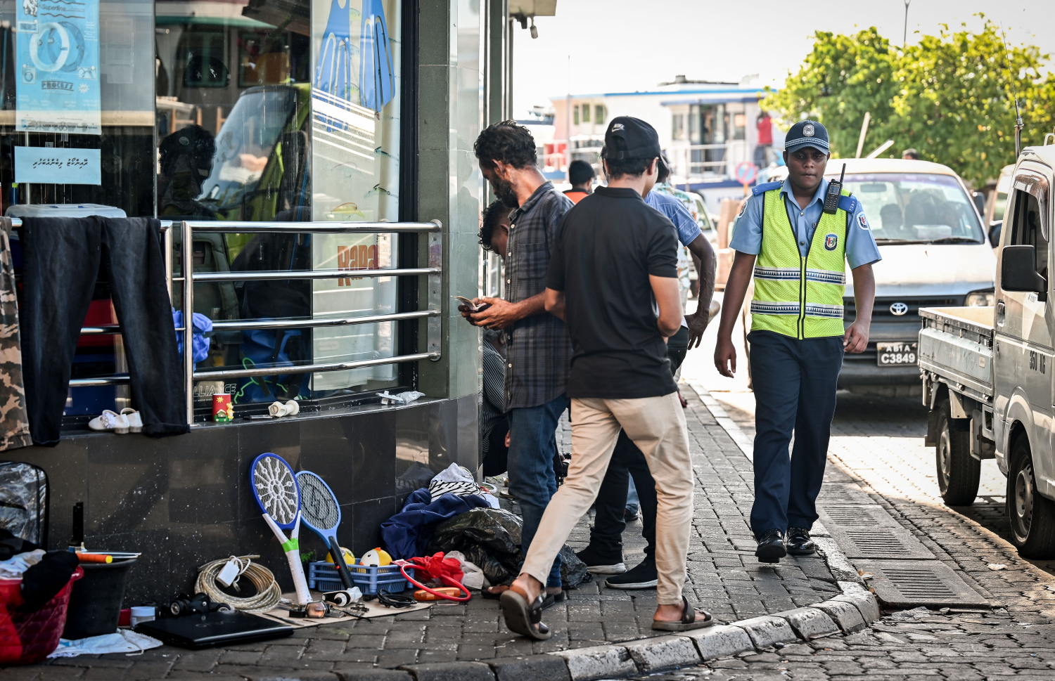 ބާޒާރުމަތީ ޕޭމެންޓުގައި ވިއްކަން ތަކެތި އަތުރާފައި ހުރިއިރު ޕޮލިހަކު އެމަގުން ހިންގާފައިދަނީ.-- ފޮޓޯ: ފަޔާޒް މޫސާ / މިހާރު