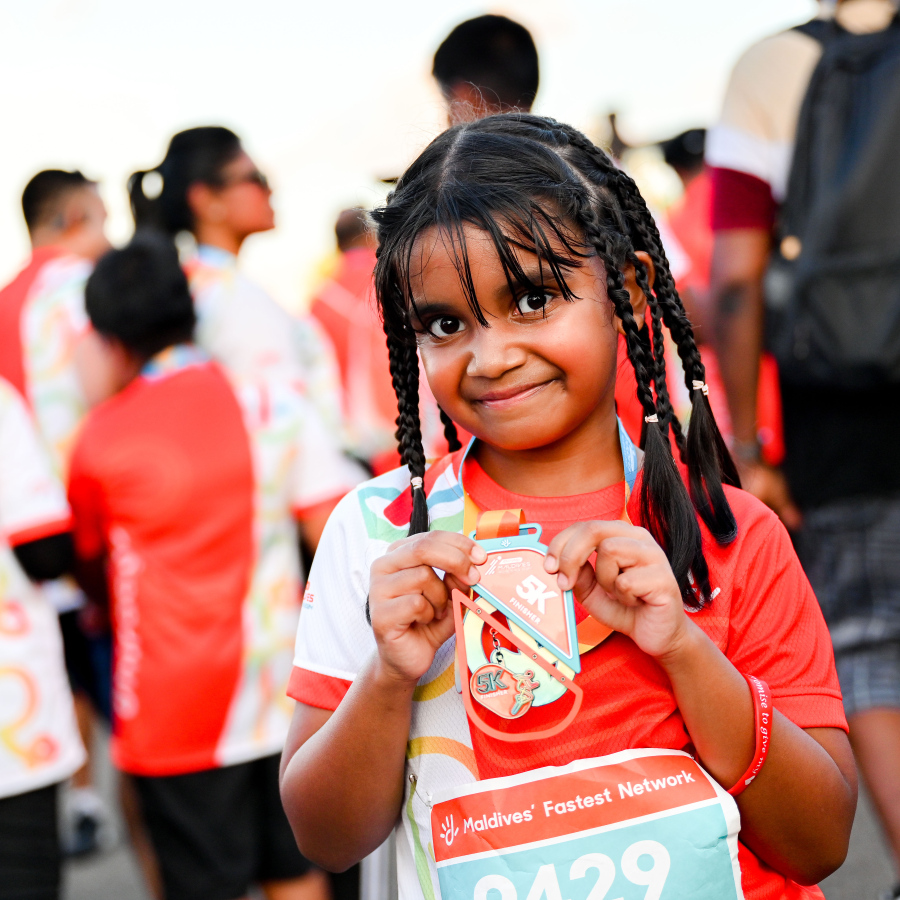 ރާއްޖޭގައި ބާއްވާ އެންމެ ބޮޑު ދުވުމުގެ އިވެންޓް ކަމަށްވާ ދިރާގު މޯލްޑިވްސް ރޯޑް ރޭހުގެ ބައިވެރިވި ކުޑަ ކުއްޖަކު މެޑެލްއާއެކު ފޮޓޯއަކަށް ހުއްޓިލައިގެން.-- ފޮޓޯ: ނިޝާން އަލީ | މިހާރު