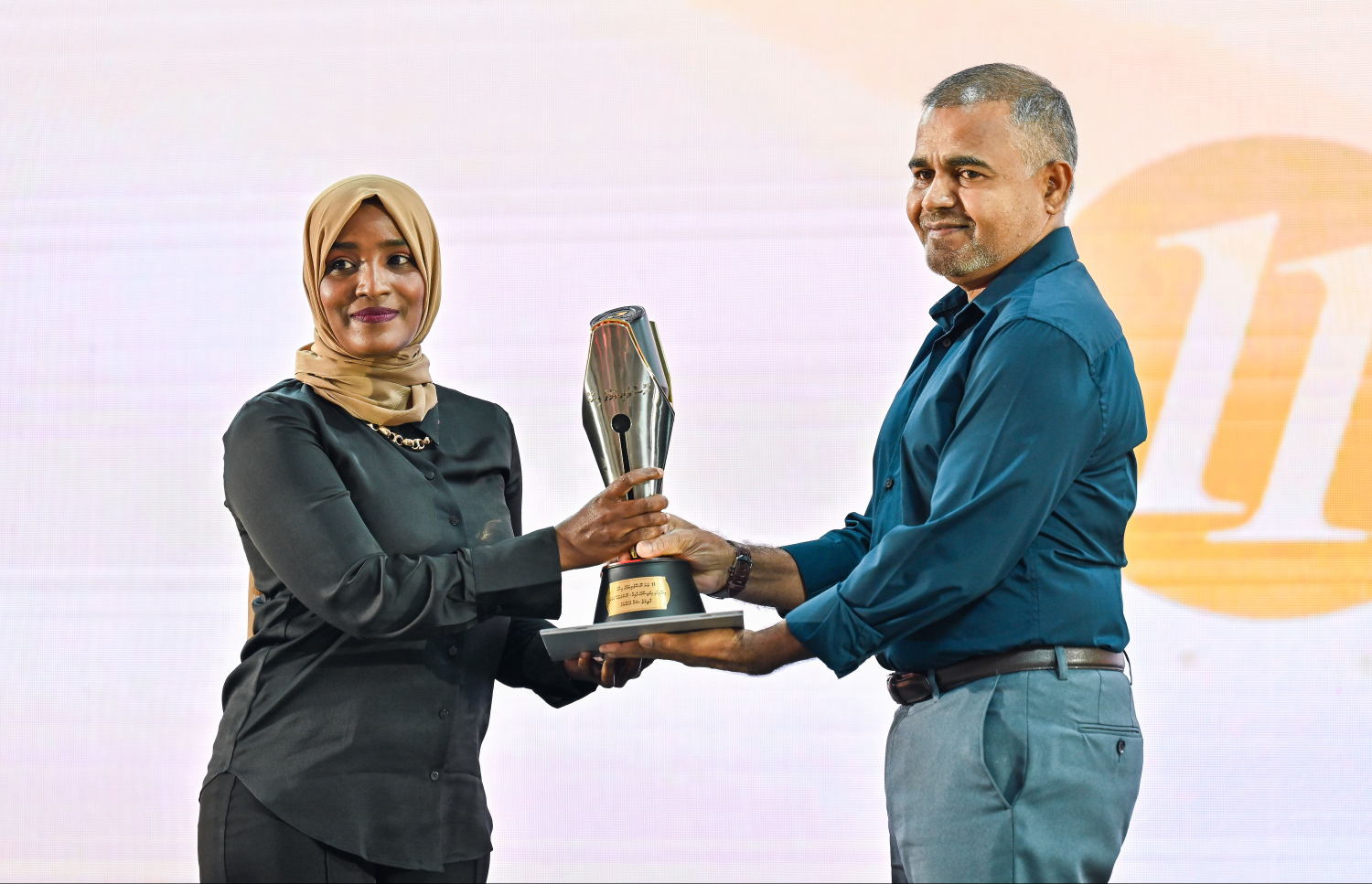 ނޫސްވެރިކަމުގެ އެވޯޑު ހަފުލާގައި ވިޔަފާރިއާ އިގުތިސާދު ދާއިރާ އިން މިދިޔަ އަހަރުގެ އެވޯޑް ލިބުނު "މިހާރު" ގެ ފާތިމަތު ޝަނާ މުހައްމަދު އެވޯޑާ ހަވާލުވަނީ.--- ފޮޓޯ: ފަޔާޒު މޫސާ | މިހާރު