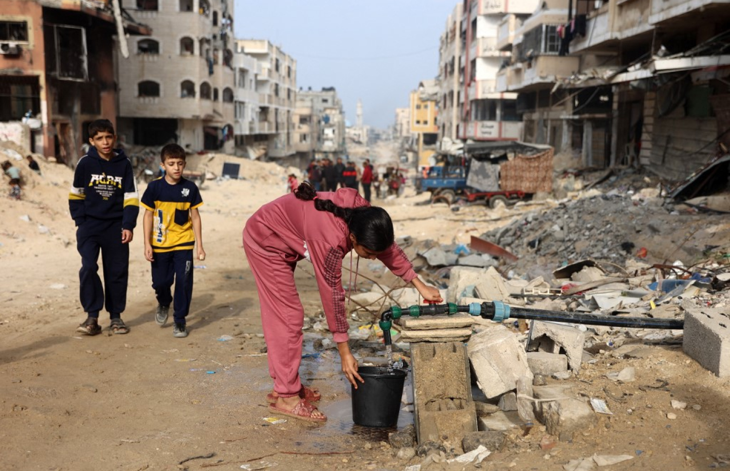 އިޒްރޭލުގެ ހަމަލާތަކުގައި ސުންނާފަތި ވެފައިވާ އަވަށެއްގައި ކުއްޖަކު އިސްކުރަކުން ބާލިދީއަކަށް ފެން އަޅަނީ: ސާފު ބޯފެނާއި ކާނާ ނުލިބި ޣައްޒާ އޮތީ ބަލިމަޑުކަމުގެ ތެރޭގައި. -- ފޮޓޯ: އޭއެފްޕީ