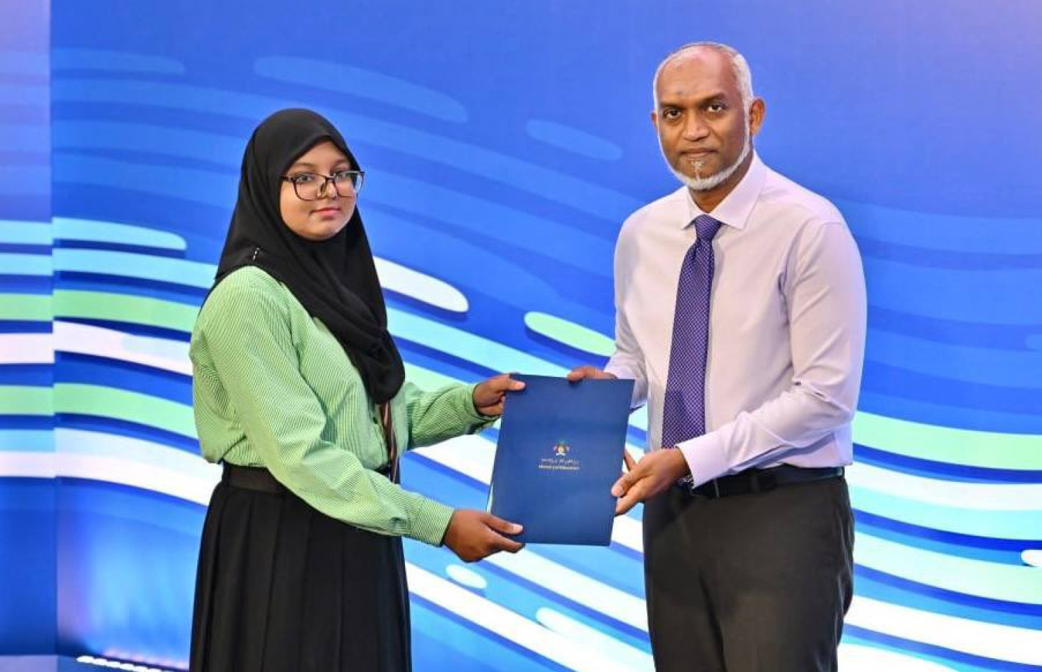 ޓީޗަރުން ތަމްރީނު ކުރުމުގެ ގައުމީ މަޝްރޫއު ފެށުމަށް ބޭއްވި ރަސްމިއްޔާތުގައި އެ ދާއިރާއިން ކުރިއަށް ދާން ބޭނުންވެ އޭލެވެލް ކިޔަވާ ދަރިވަރަކަށް ރައީސް ޑރ. މުހައްމަދު މުއިއްޒު ސްކޮލާޝިޕް ލިޔުން ހަވާލުކޮށްދެއްވަނީ.-- ފޮޓޯ: ރައީސް އޮފީސް