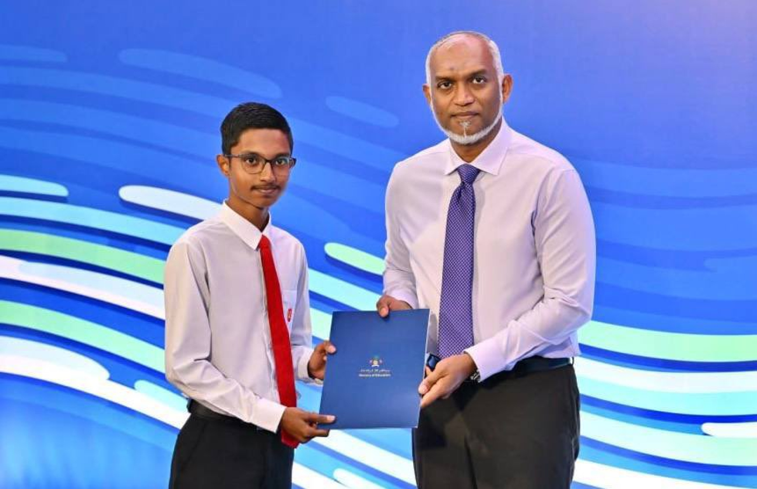 ޓީޗަރުން ތަމްރީނު ކުރުމުގެ ގައުމީ މަޝްރޫއު ފެށުމަށް ބޭއްވި ރަސްމިއްޔާތުގައި އެ ދާއިރާއިން ކުރިއަށް ދާން ބޭނުންވެ އޭލެވެލް ކިޔަވާ ދަރިވަރަކަށް ރައީސް ޑރ. މުހައްމަދު މުއިއްޒު ސްކޮލާޝިޕް ލިޔުން ހަވާލުކޮށްދެއްވަނީ.-- ފޮޓޯ: ރައީސް އޮފީސް