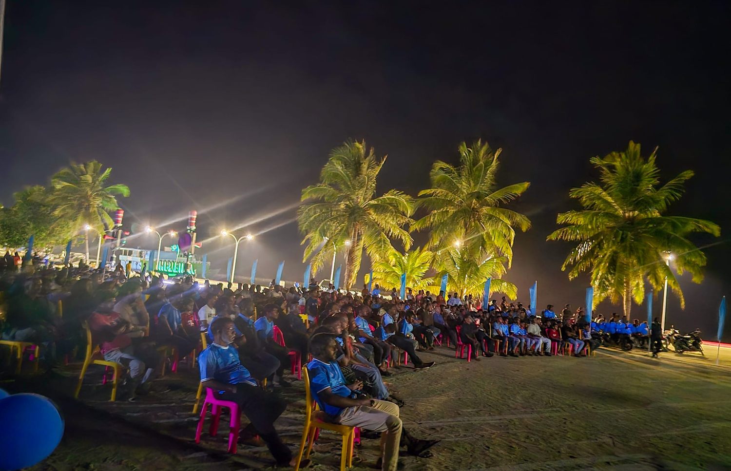 ގޯލްޑް ކަޕްގައި އަލިފުށި ކުޅުނު މެޗު، އެ ރަށު ބަނދަރު ސަރަހައްދުގައި ބަހައްޓާފައި ހުރި ބޮޑު ސްކްރީނުން މެޗު ބަލަން އެ ރަށުގެ ގިނަ ބަޔަކު ބަނދަރު މައްޗަށް ހާޒިރުވެ. --- ފޮޓޯ: ކަންނާޑި