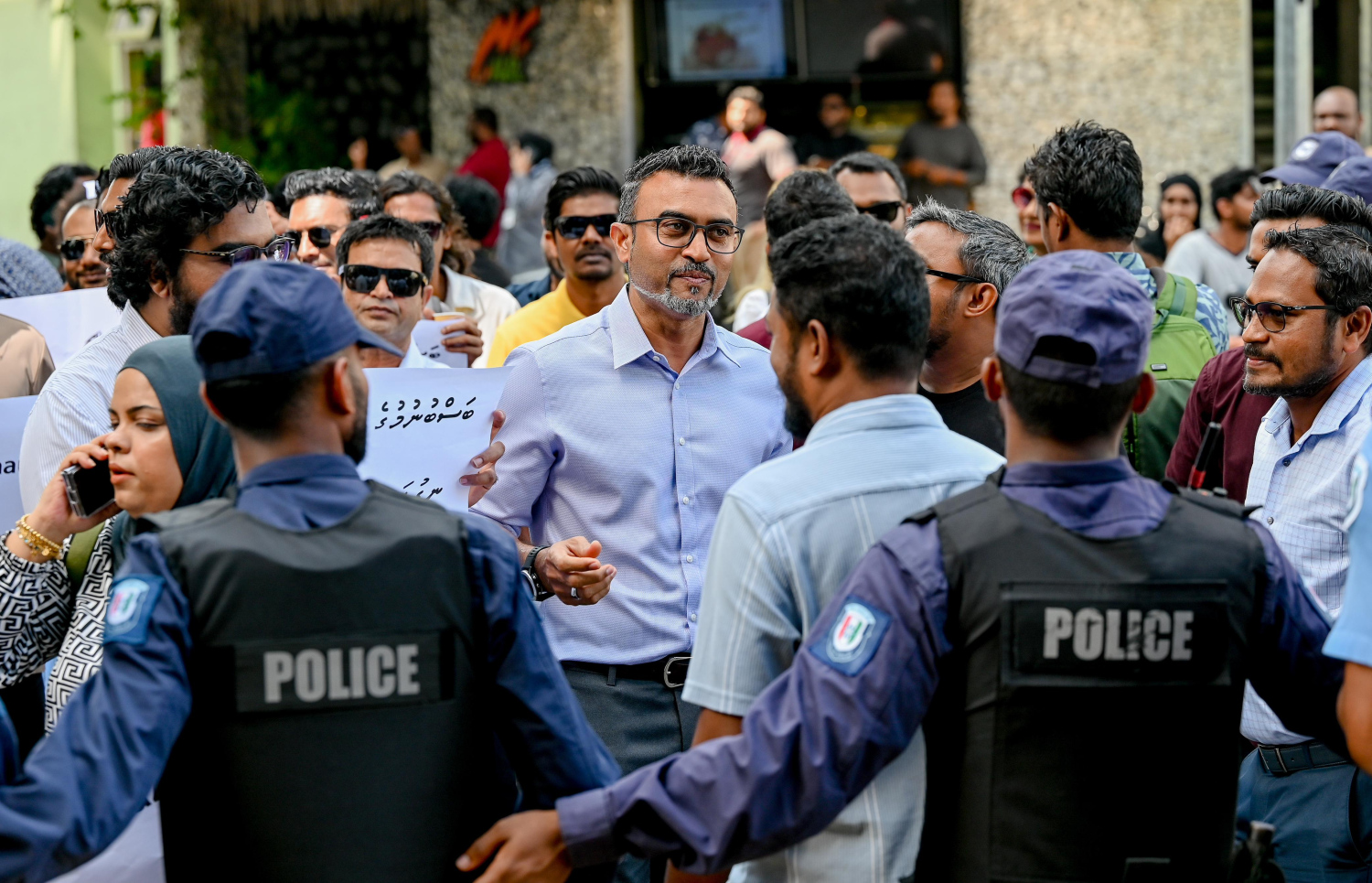 ޝާފިއު ފުލުހަށް ހާޒިރުކުރުމުން އެމްޑީޕީގެ ބައެއް އިސްވެރިންނާއި ސަޕޯޓަރުން ޕޮލިސް ސްޓޭޝަން ކައިރީގައި ނުރުހުން ފާޅުކުރަނީ.-- ފޮޓޯ: ނިޝާން އަލީ | މިހާރު