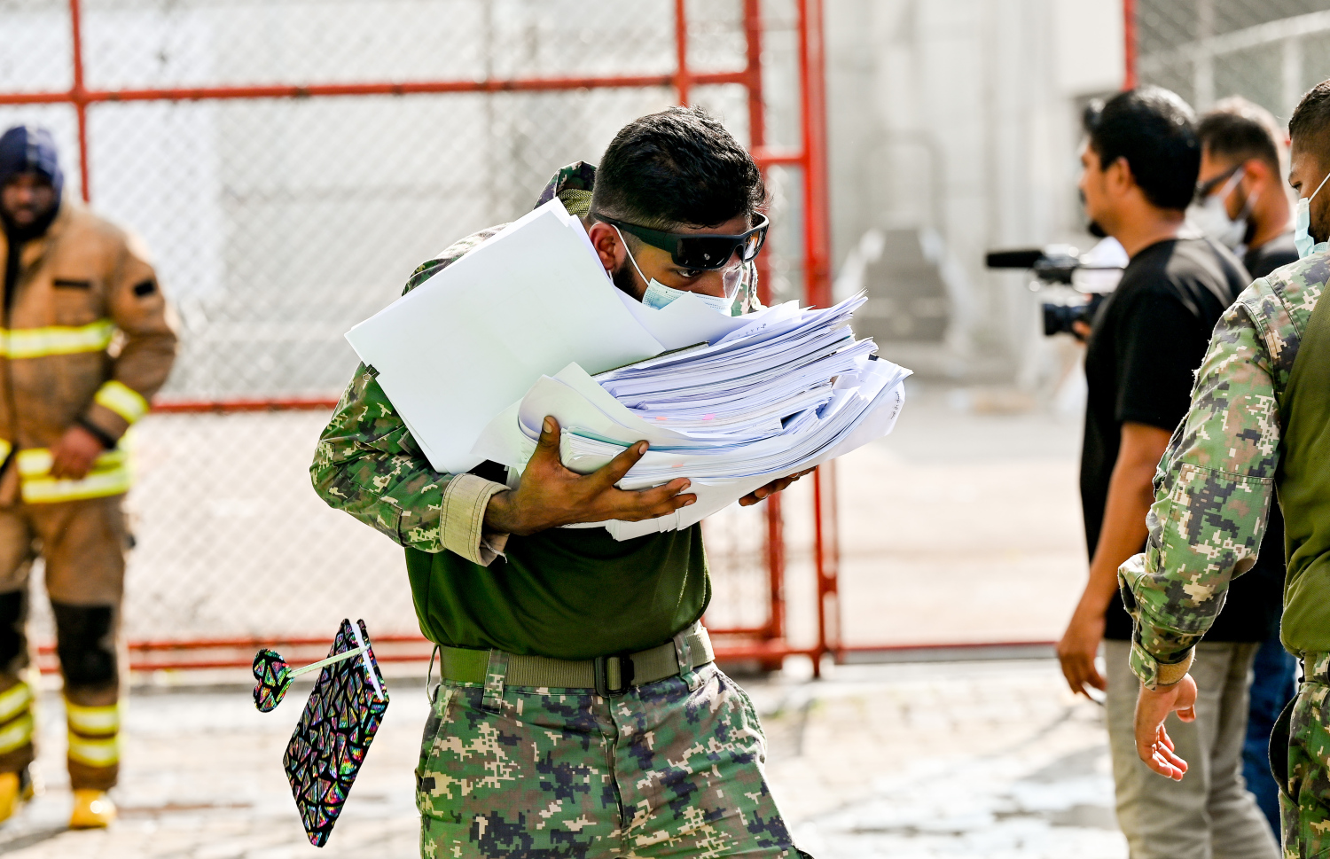 މ. ގްރީން ބިލްޑިންގައި ހިންގާ އޮފީހަކުން ސަލާމަތްކުރެވެން ހުރި ލިޔެކިޔުންތަކެއް ސިފައިންގެ މީހަކު އެތަނުން ނެރެގެން ގެންދަނީ.-- ފޮޓޯ: ނިޝާން އަލީ | މިހާރު