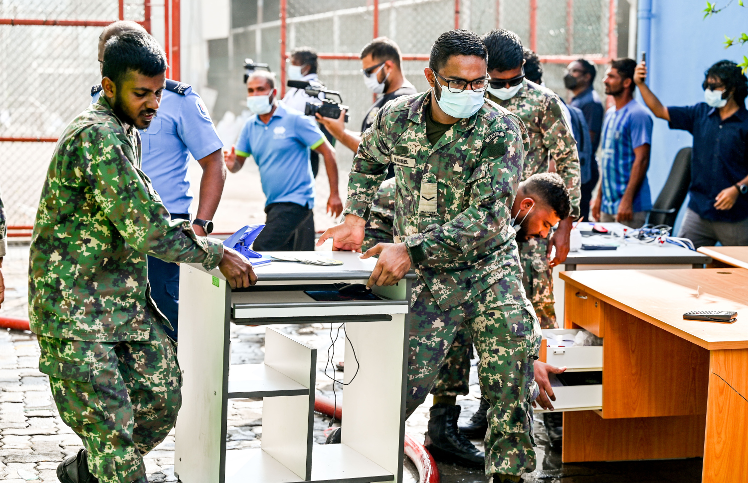 މ. ގްރީން ބިލްޑިންގައި ހިންގާ އޮފީހަކުން ސަލާމަތްކުރެވެން ހުރި ބައެއް ސާމާނު ސިފައިންނާއި ފުލުހުން ގުޅިގެން އެތަނުން ނެރެނީ.-- ފޮޓޯ: ނިޝާން އަލީ | މިހާރު