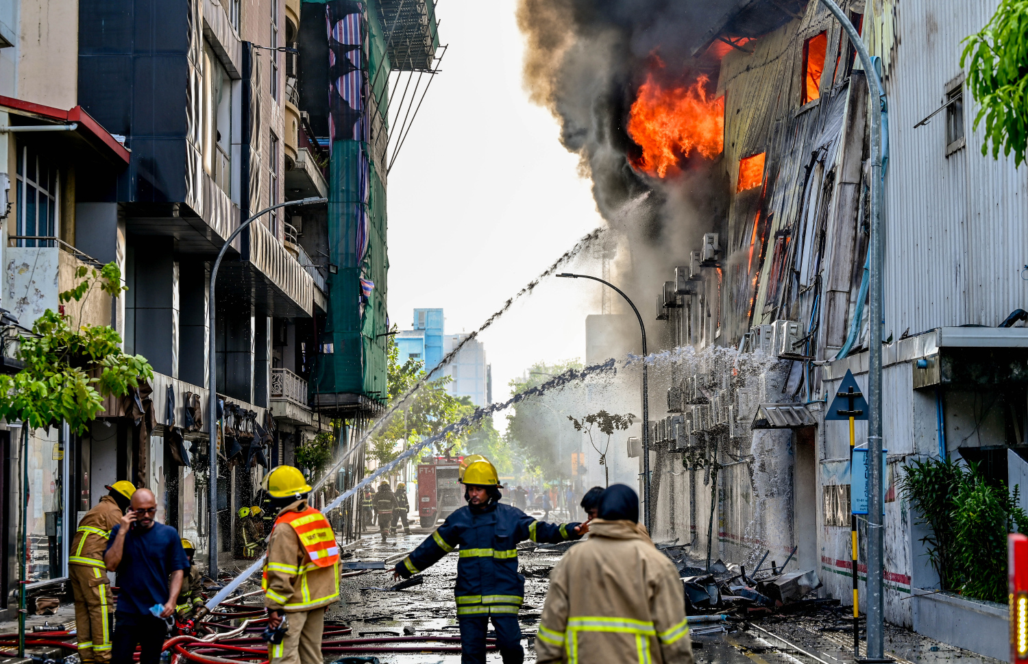 މ. ގްރީން ބިލްޑިންގައި ރޯވި އަލިފާންގަނޑު ނިއްވާލުމުގެ މަސައްކަތް އެމްއެންޑީއެފްގެ ފަޔާ ފައިޓަރުން ކުރަނީ.-- ފޮޓޯ: ނިޝާން އަލީ | މިހާރު