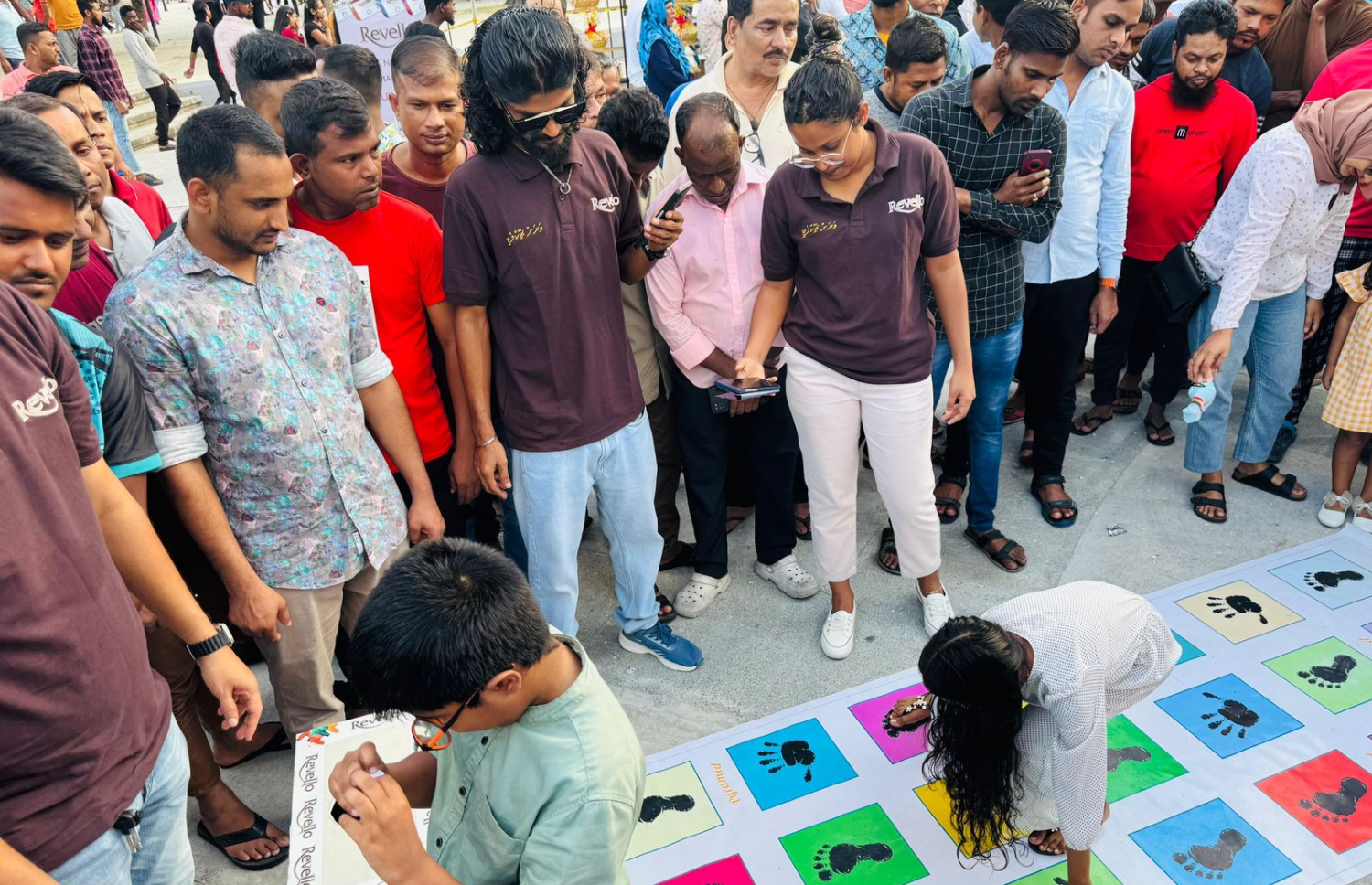 ޕިރަމިޑުން ބޭއްވި އިވެންޓުގައި ކުޑަކުއްޖަކު ގޭމެއް ކުޅެނީ. މި އިވެންޓަކީ ރެވެލޯ ޗޮކްލެޓުގެ ރަހަ ދައްކާލުމަށް މަޖާ ގޭމުތަކަކާ އެކު ބޭއްވި އިވެންޓެއް.