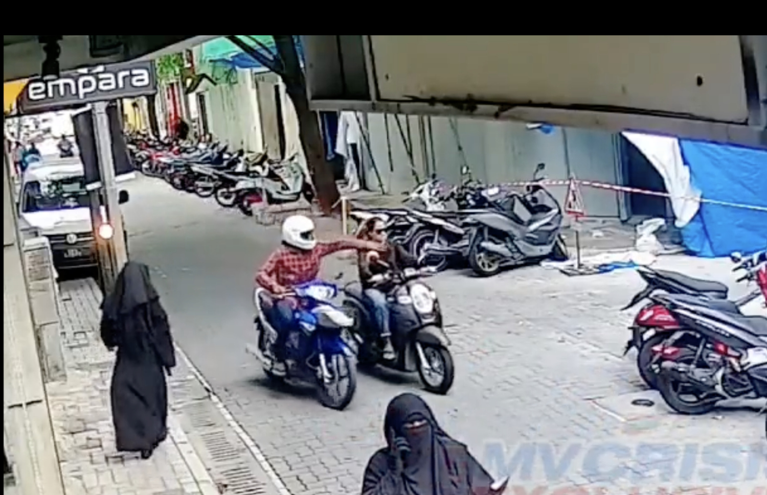 ސައިކަލުގައި ދިޔަ އަންހެނެއްގެ ކަރުގައި އޮތް ފަށް ޖަހައިގަންނަ ވީޑިއޯގެ މަންޒަރެއް.