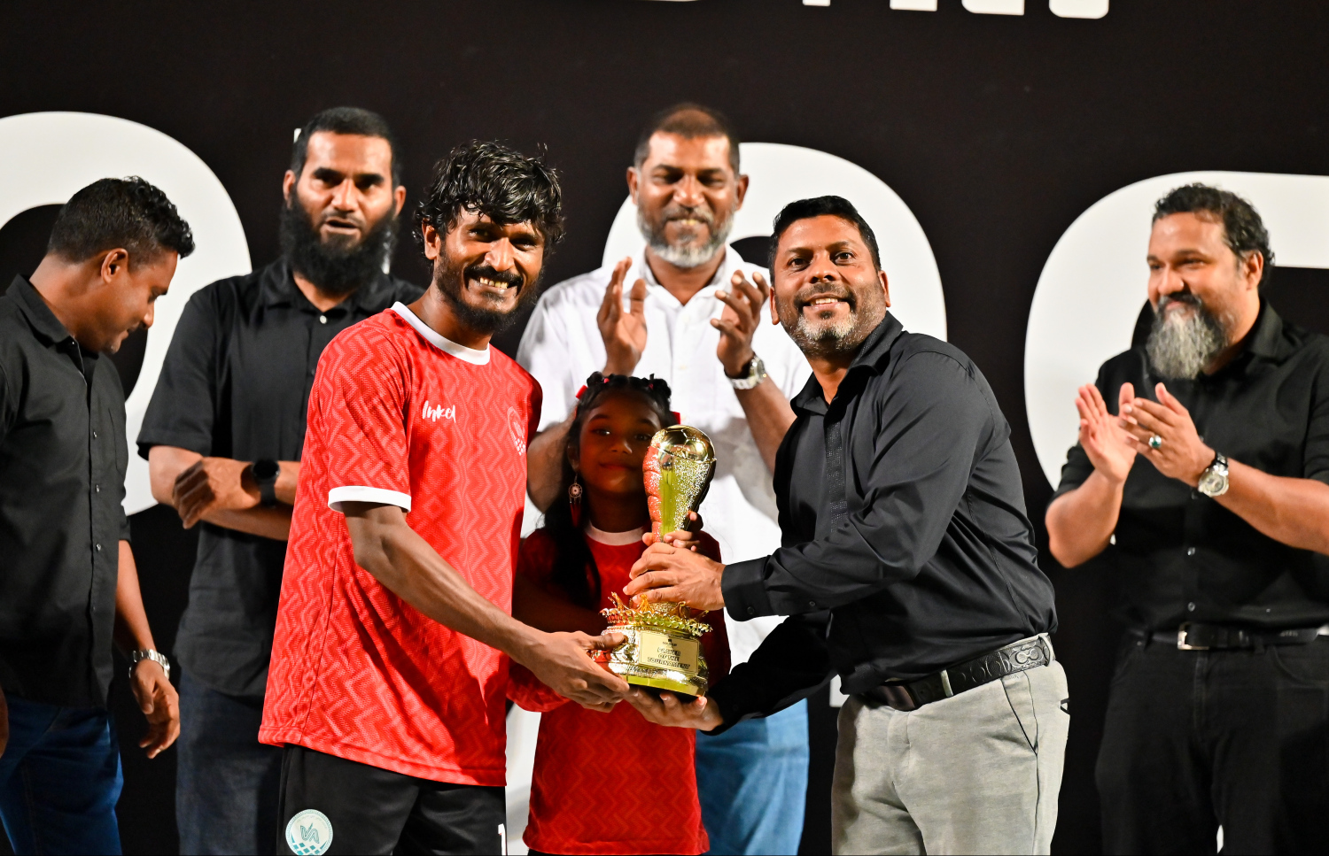 ގޯލްޑް ކަޕް މުބާރާތުގެ މޮޅު ކުޅުންތެރިޔާގެ މަގާމު ހޯދި އޭދަފުށި ޓީމުގެ މުހައްމަދު ފާސިރަށް، ސްޕޯޓްސް މިނިސްޓަރު ރާފިއު ޓްރޮފީ ހަވާލުކޮށްދެއްވަނީ.--- ފޮޓޯ: ފަޔާޒް މޫސާ | މިހާރު