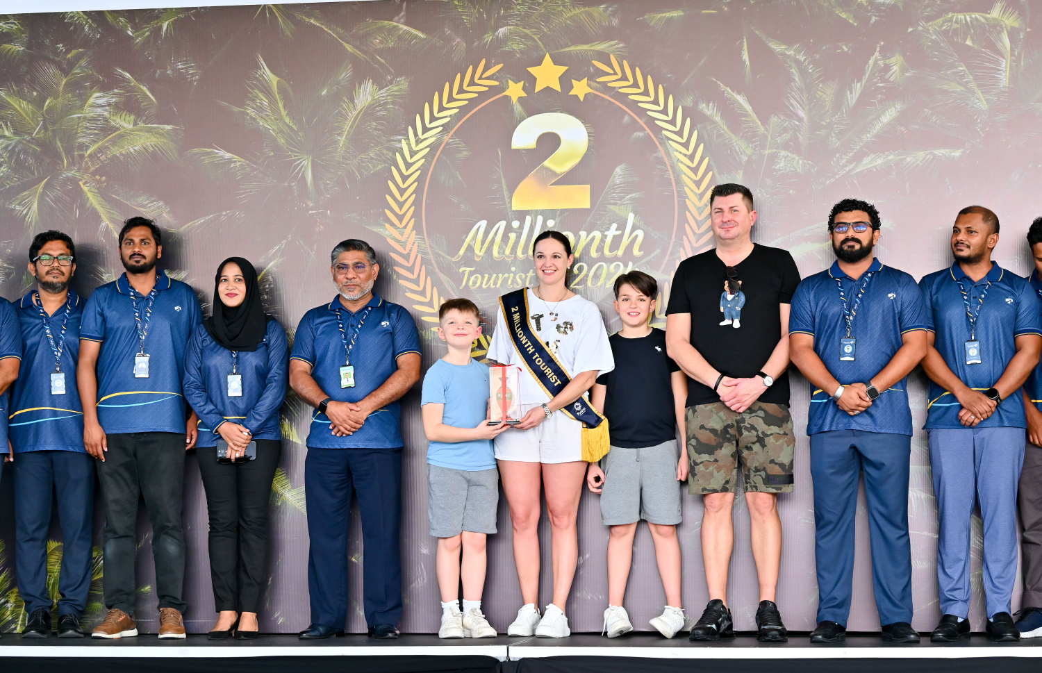 މިއަހަރު ރާއްޖެއަށް އައި ދެ މިލިއަން ވަނަ ޓޫރިސްޓުގެ ޝަރަފު ހޯދި އޮސްޓްރިއާގެ އަންހެން މީހާއެކު އެމްއޭސީއެލްގެ މުވައްޒަފުން ފޮޓޯއަކަށް ހުއްޓިިގެން .-- ފޮޓޯ: ނިޝާން އަލީ / މިހާރު